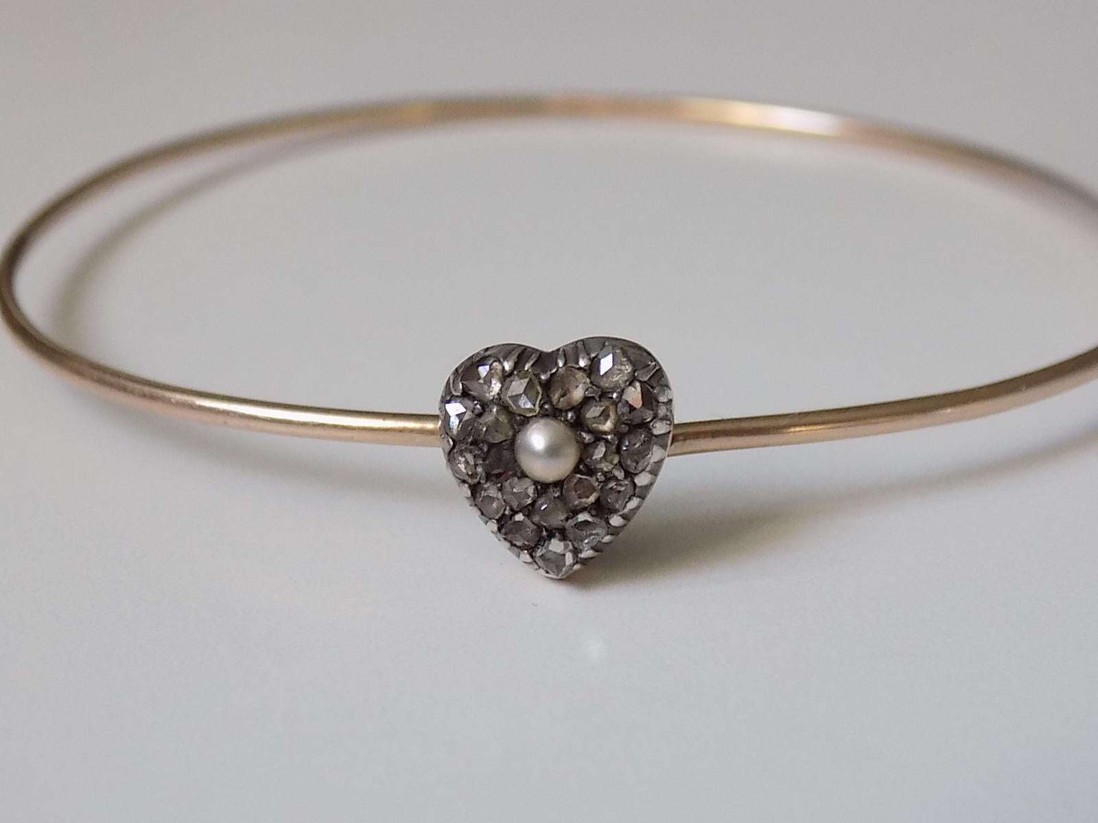 A rare Victorian Rose cut Diamond and split Pearl Heart bangle in rose gold and silver. English Origin.
Width inside 55mm
Heart 10mm x 9mm
Weight 3.7gr
Unmarked.