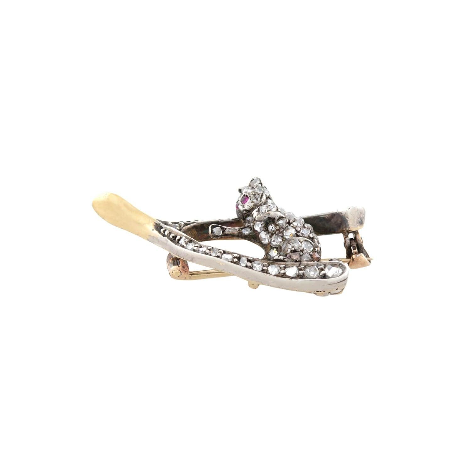 A lovely pin from the Victorian (ca1880s) era! Crafted in 15kt yellow gold and topped in sterling silver, this beautiful 3-dimensional pin depicts a playful diamond kitten sitting atop a wishbone. The sweet kitten has delicate ruby eyes, pointed