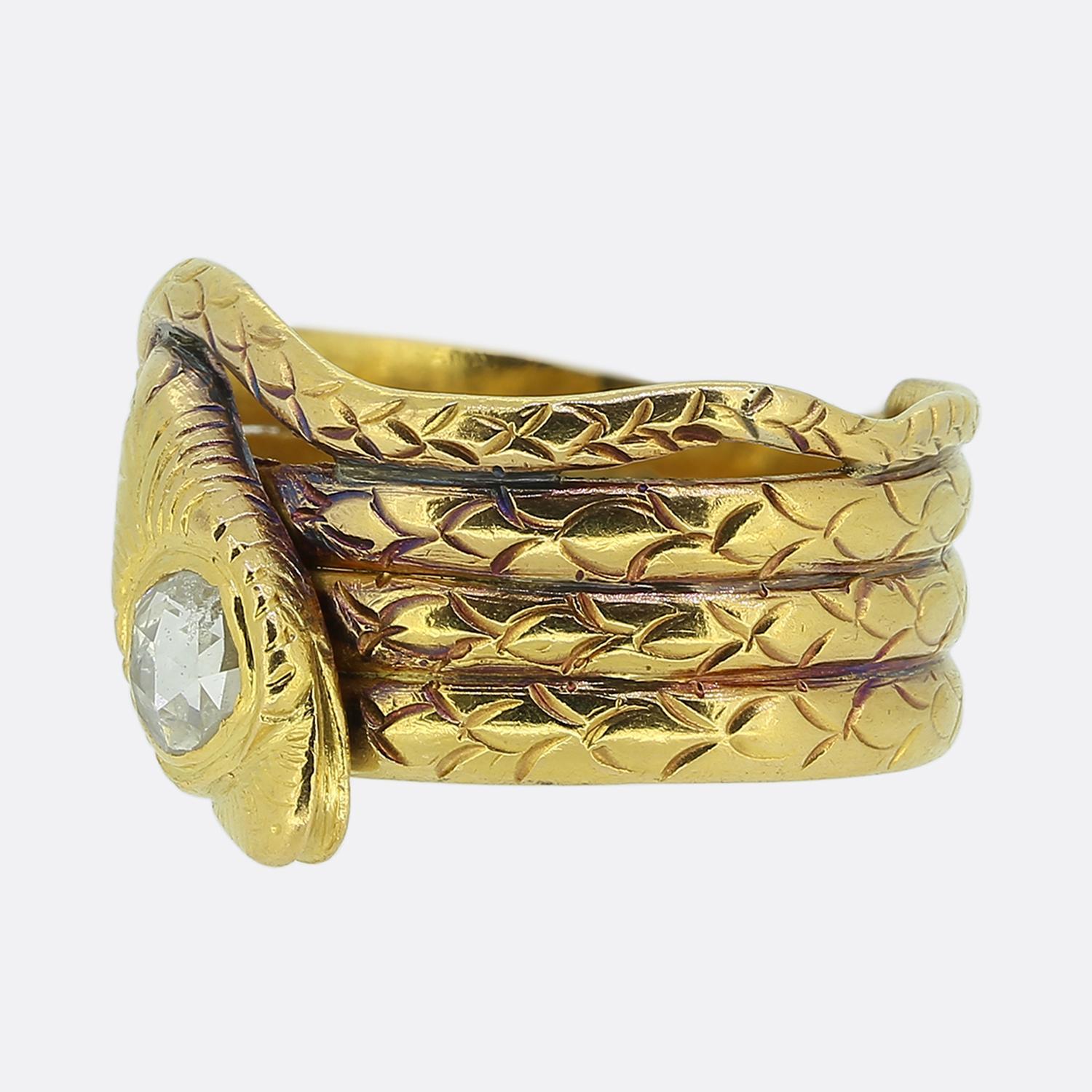 Aquí tenemos un cautivador anillo de serpiente fabricado durante la época victoriana. Fabricada en oro amarillo de 18 quilates, esta pieza muestra un motivo de serpiente enroscada con escamas cuidadosamente grabadas y detalladas. La cabeza de la