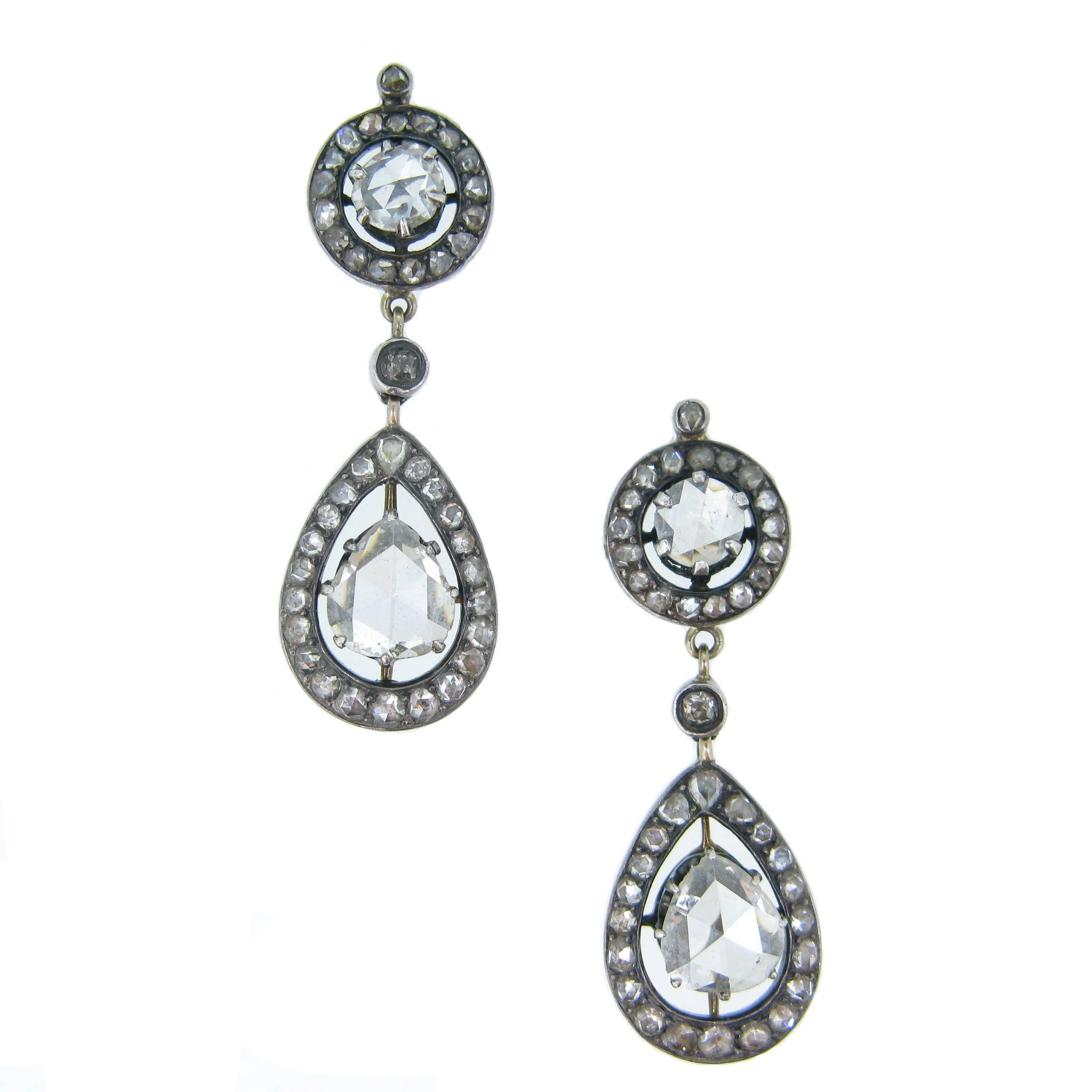 A unique pair of diamonds drops earrings. The tops are set with round rose cut diamonds, surrounded with 18 rose diamonds and the bottoms have a pear shapes. The pear shape rose cut diamond are around 1ct. They are also surrounded with 22 rose.