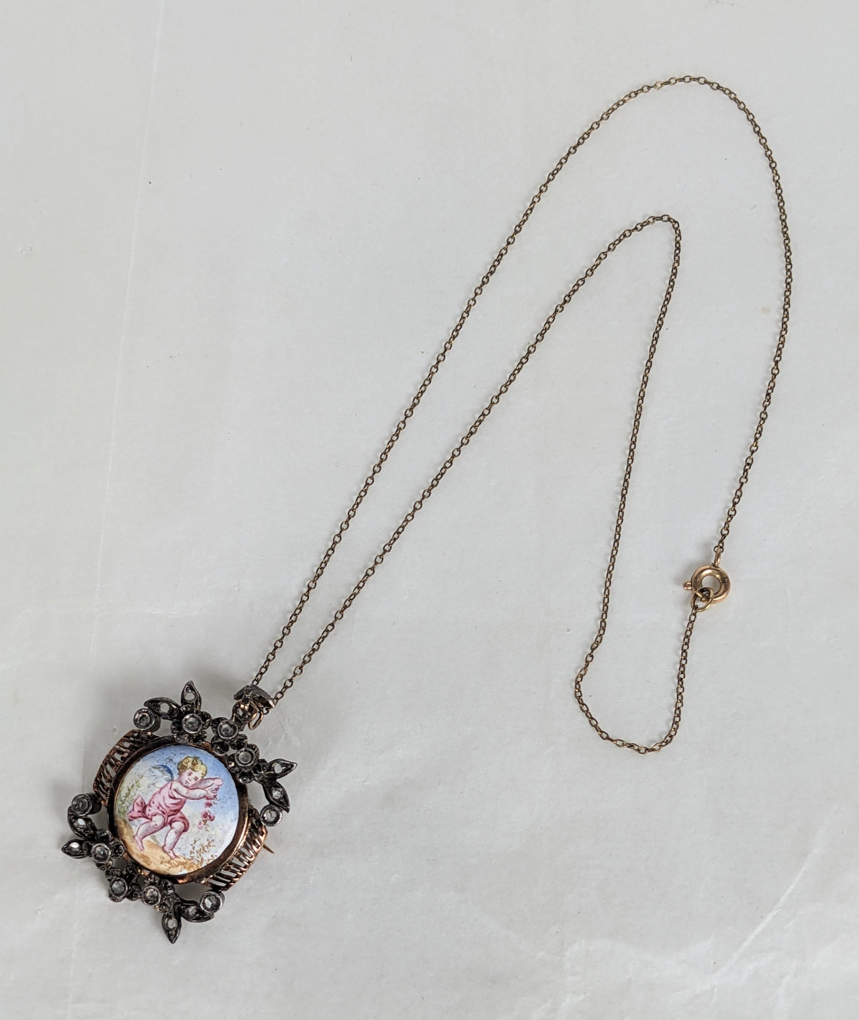 Spilla con ciondolo con diamante rosa e smalto di epoca vittoriana, risalente agli anni '70 del XIX secolo. Incantevole disegno con angeli putti che giocano con i fiori. Probabilmente di origine francese, con porcellana dipinta a mano in una cornice