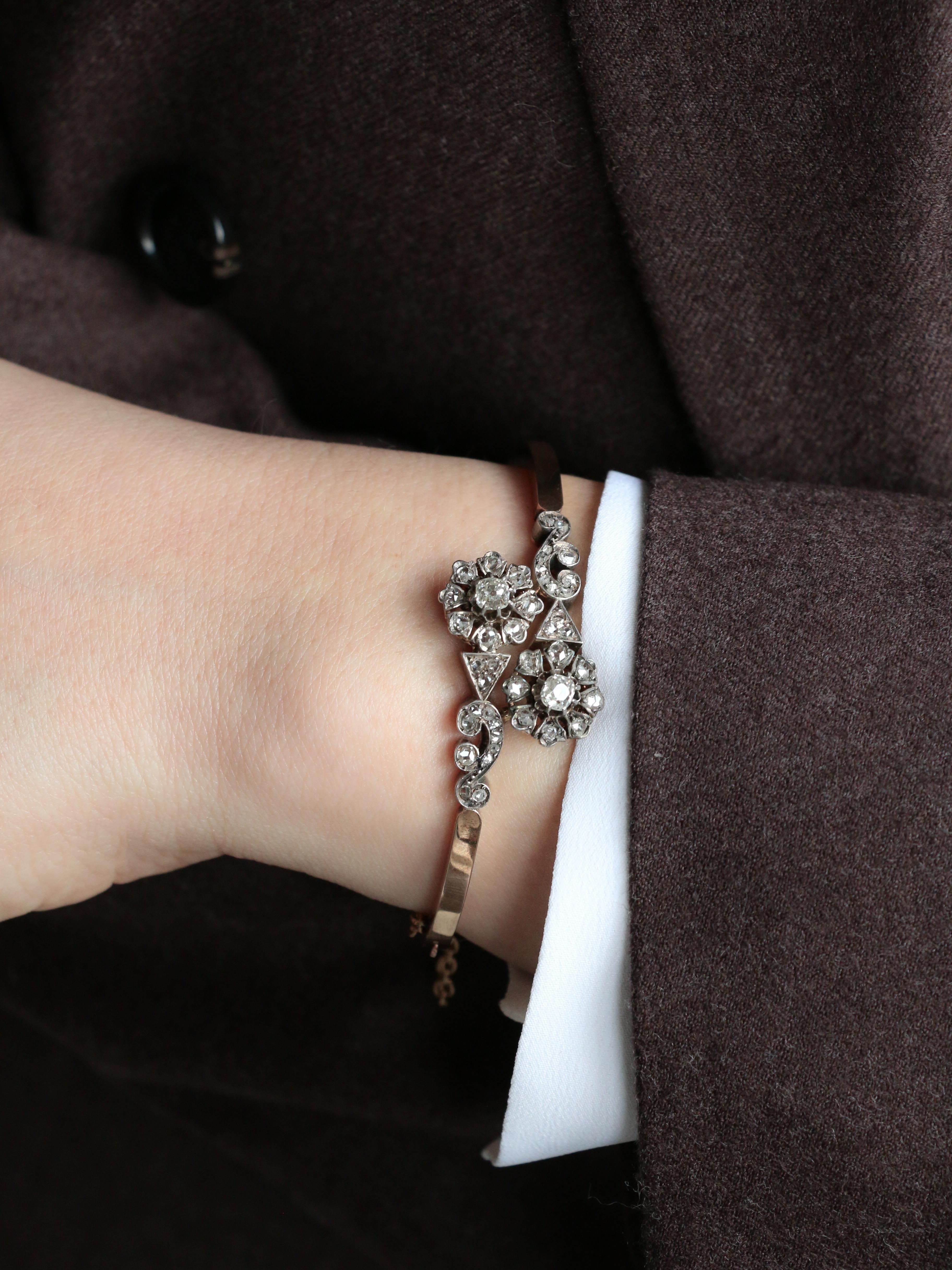 Pulsera antigua de oro rosa, plata y diamantes talla rosa

Pulsera brazalete de oro rosa de 18 quilates (750‰) y plata, compuesta por dos flores estilizadas, cada una engastada en el centro con un diamante talla Old Mine de aproximadamente 0,35