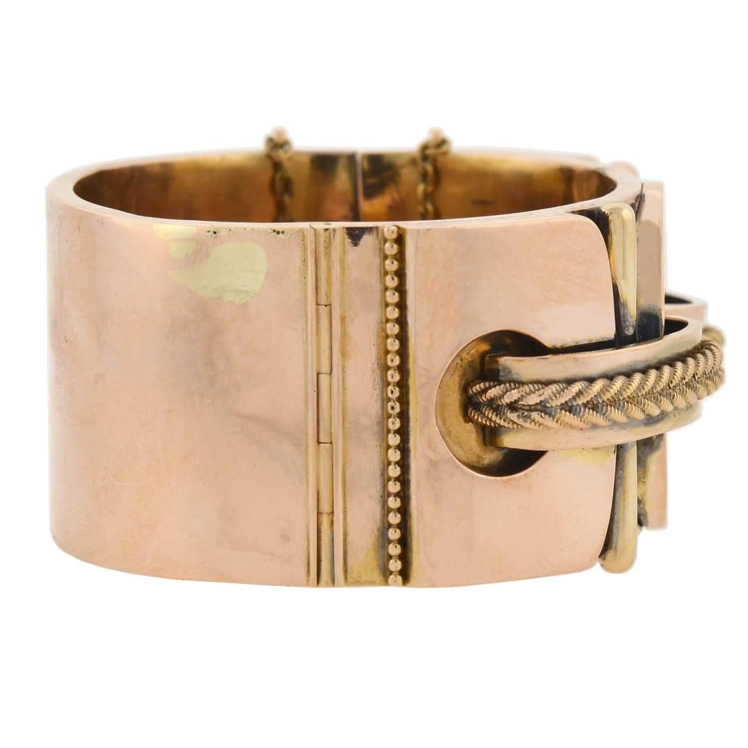 An incredible gold bracelet from the Victorian (ca1880) era! This wide, three-dimensional bangle is crafted in vivid 15kt rose gold (indicating its English origin) and has a fabulous double buckle design. The elaborate design rests across the front