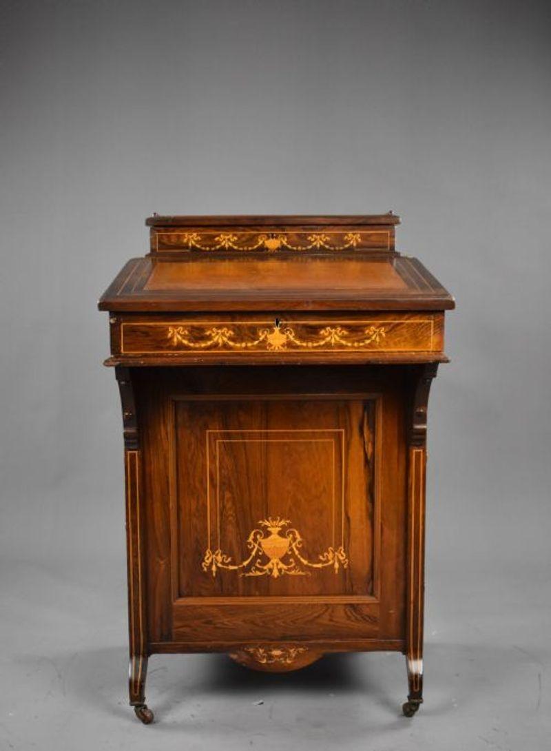 For sale is a Victorian rosewood inlaid davenport, inlaid with swags and urns above a leather writing surface, with drawers to one side and dummy drawers on the opposing side. Overall the davenport is in good condition, with minor losses and wear