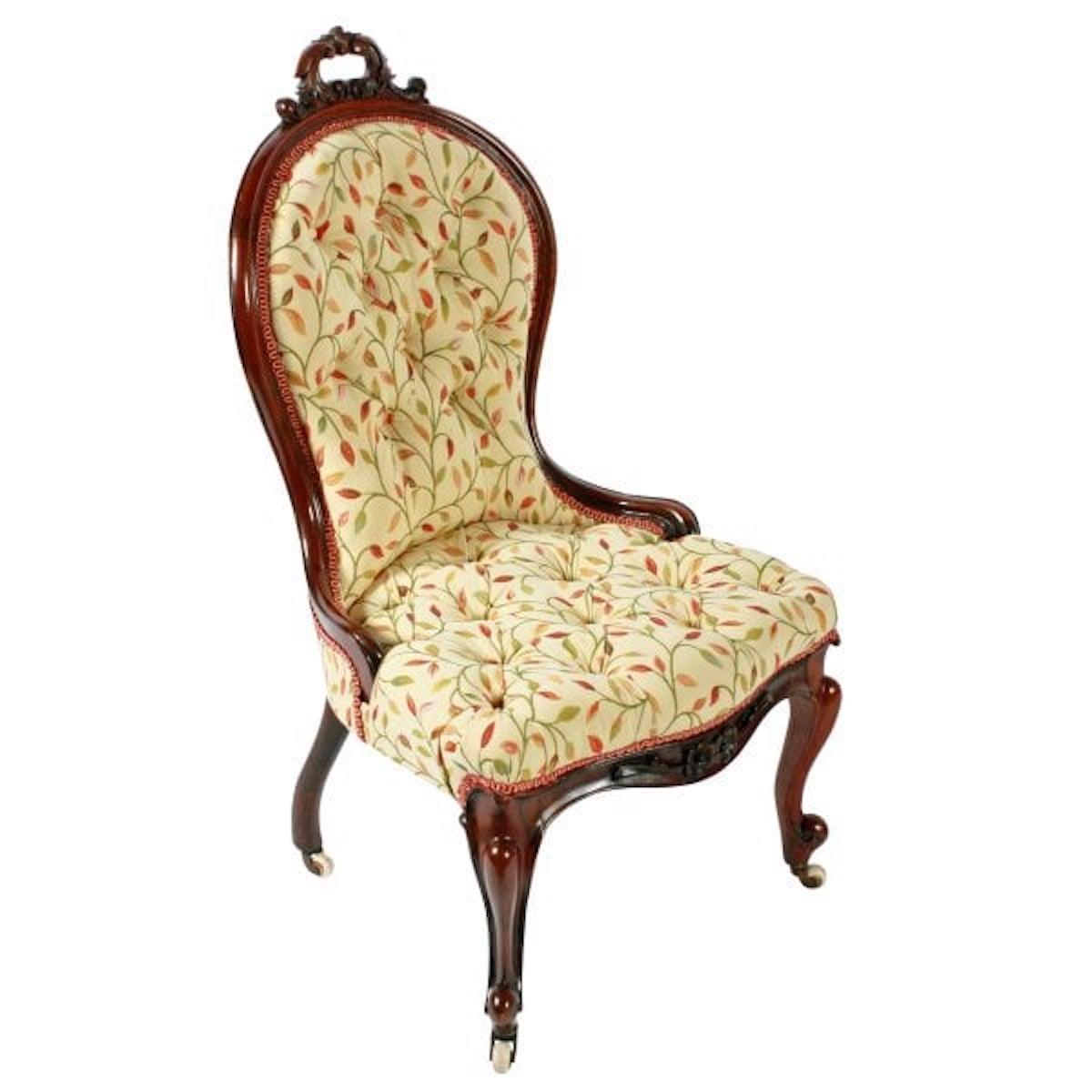 A 19th century Victorian rosewood upholstered lady's chair.

The chair has a shaped back with a scrolling acanthus carved decoration hand grip to the top.

The front legs are cabriole shaped with scroll carved detail and brass and pottery