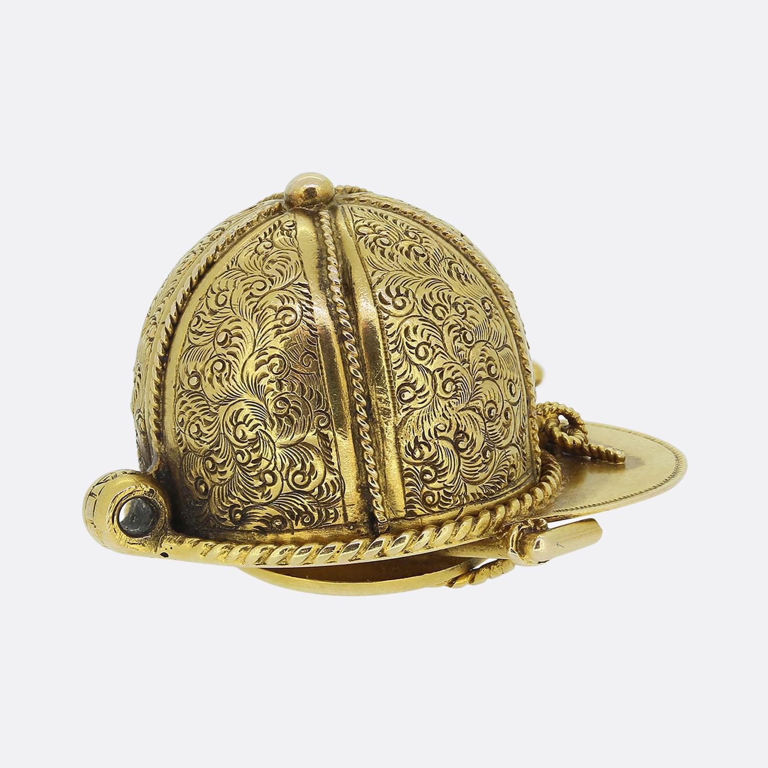 Here we have a remarkable creation taken from the Victorian era. This unique antique pendant has been crafted from a warm 18ct yellow gold into the shape of a horse riding hat. The hat itself showcases ornately engraved decoration with finely roped