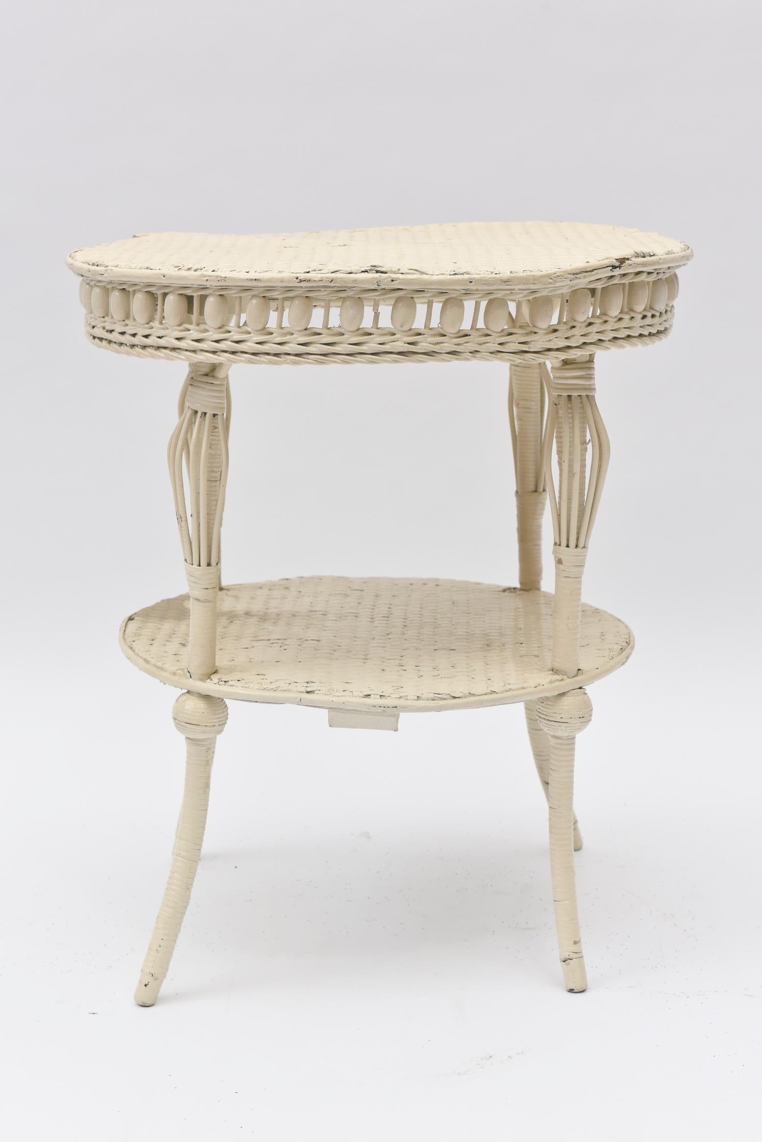 Dieser Korbtisch von 1898 ist ein hervorragendes Beispiel für die viktorianische Ära von Heywood Bother und Wakefield Company. Es ist eine Kombination aus einer Schürze mit Holzperlen und gespreizten Beinen in Form eines Vogelkäfigs, alles Elemente