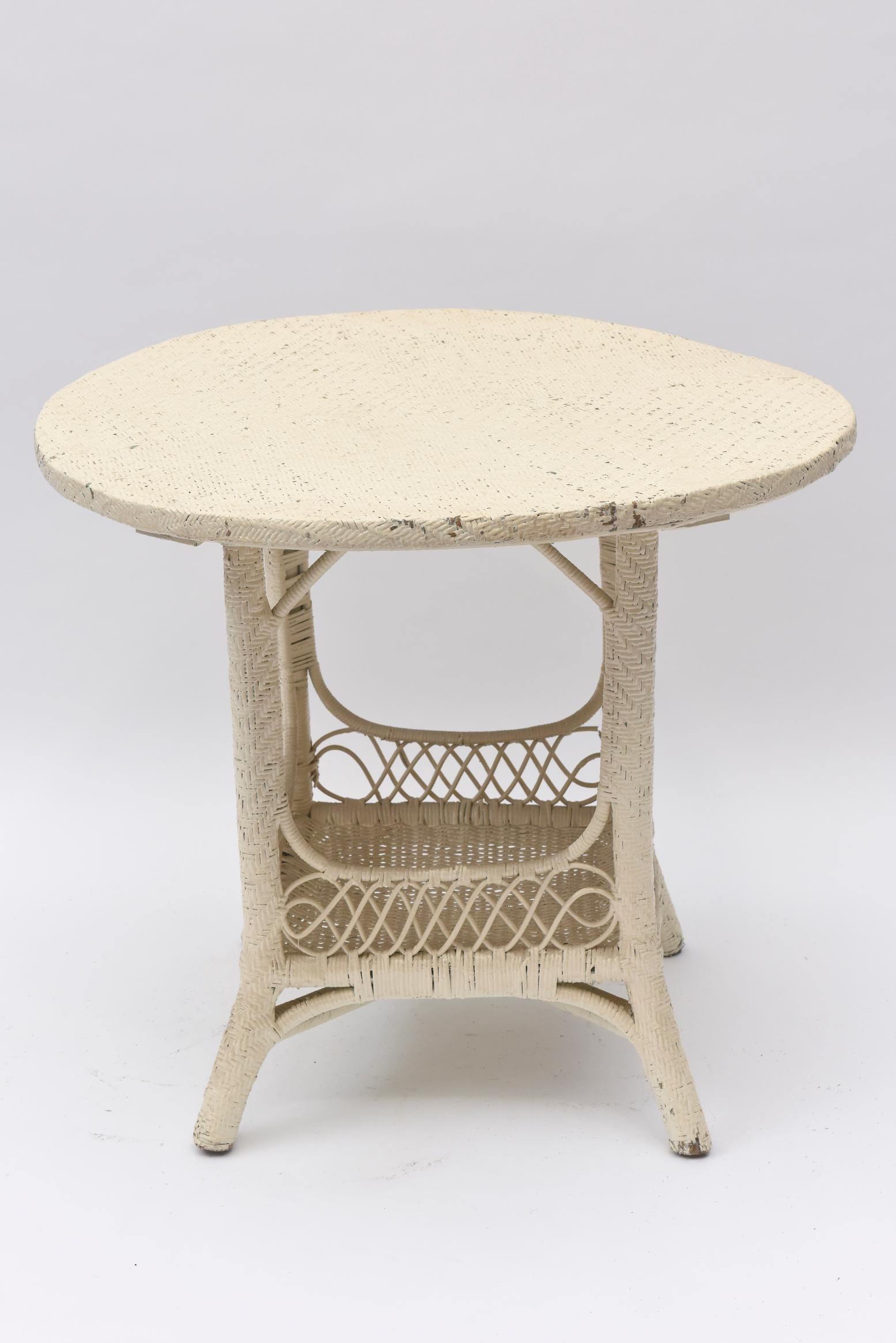 This circular Victorian wicker side table with a woven enclosed bottom shelf that may be used for magazines or books. Though it is from the Victorian era, it is elegant in its simplicity. The top of the table is woven as well.