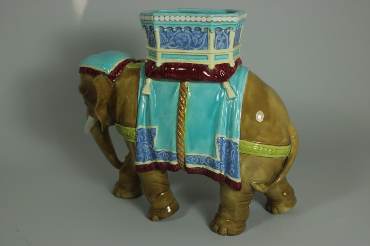 Royal Worcester Majolica which features an elephant, with a howdah on it's back. Coloration: Turquoise, are predominant. The piece bears maker's marks for the Royal Worcester pottery. English diamond registration mark for the date ??/??/1869.