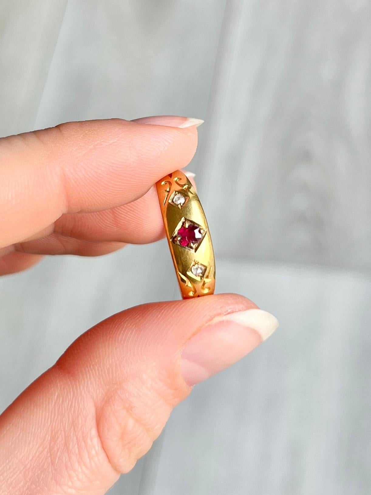 This classic band is modelled in 18carat gold and the Ruby which is set in the diamond shaped setting measures 10pts and the rose cut diamonds measure 3pts each. Hallmarked London 1896.

Size: Q or 8 1/4 
Width: 6mm

Weight: 2.3g
