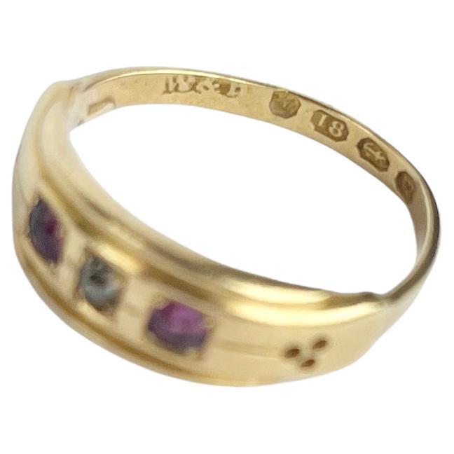 The central diamond in this glossy 18ct gold band measures 7pts and is set in a square setting. The rubies that sit either side of this stone measure 8pts each. Hallmarked Birmingham 1886.

Ring Size: N or 6 3/4 
Band Width: 6.5mm 

Weight: 3g 