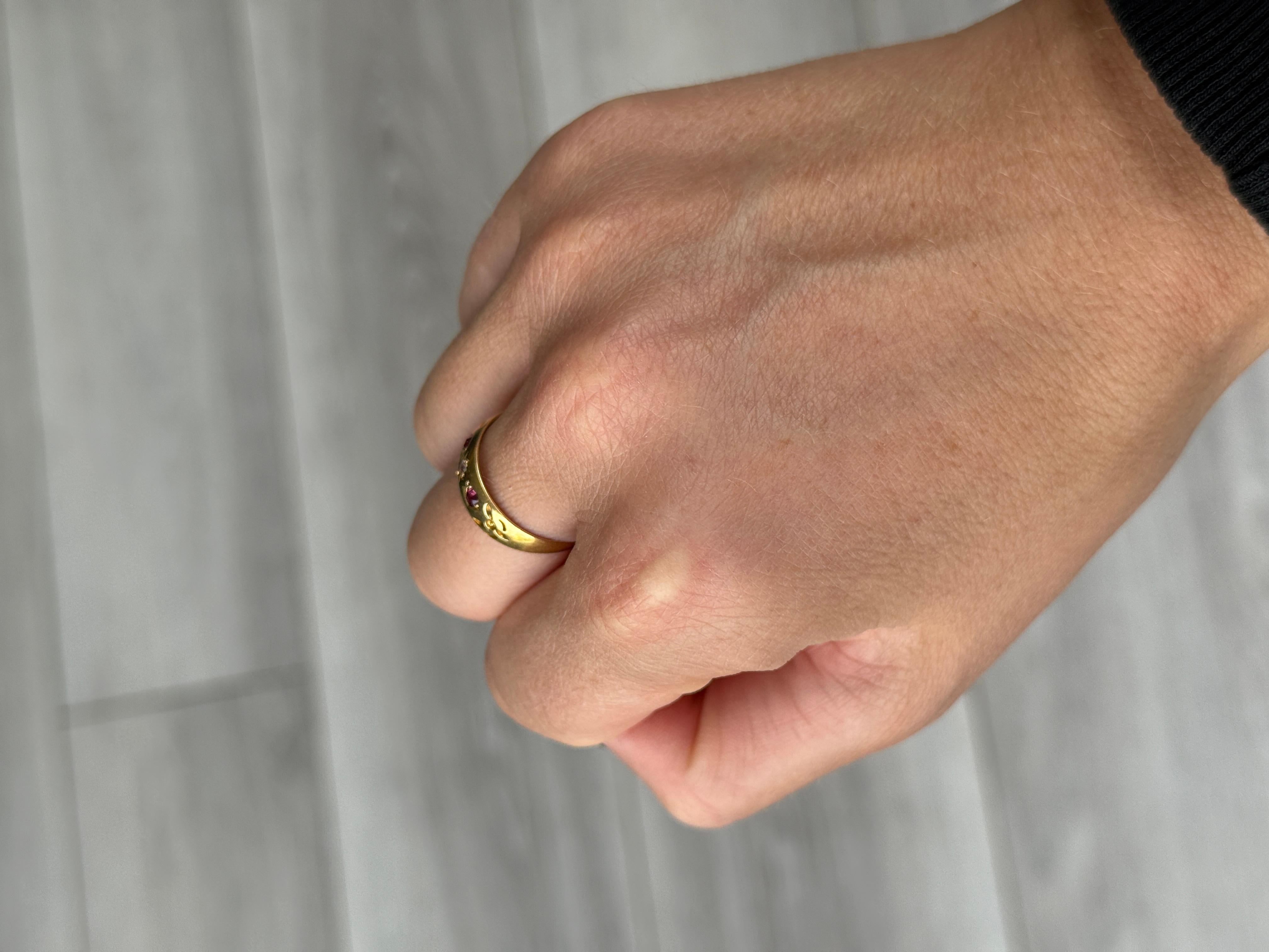 Der zentrale Diamant in diesem glänzenden 18-karätigen Goldband misst 5 Pence und ist in einer Sternfassung gefasst. Die Rubine, die auf beiden Seiten dieses Steins sitzen, messen jeweils 7 Pence. Gepunzt: Chester 1896.

Ring Größe: O oder 7