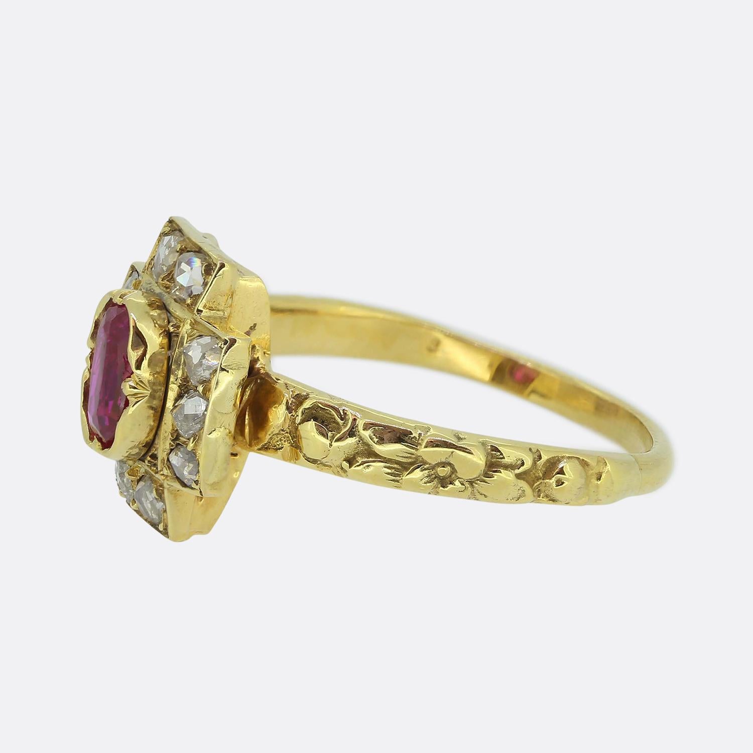 Here we have a beautiful cluster ring taken from the Victoria era. This antique piece has been crafted from a rich 18ct yellow gold and showcases an oval faceted vivid red ruby with a pinky undertone at the centre of the face. This principal stone