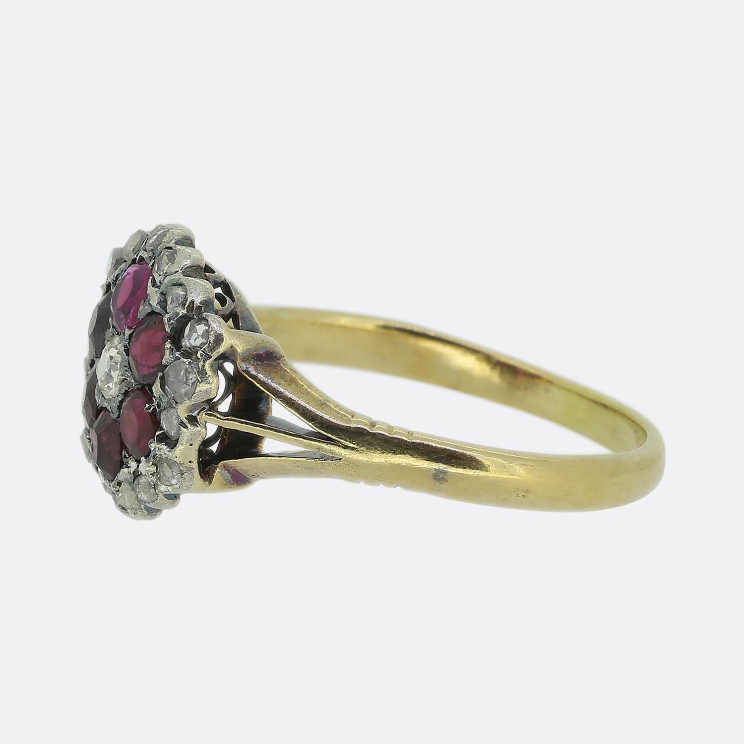 Hier haben wir einen viktorianischen Clusterring mit einer bezaubernden Anordnung von Steinen. In der Mitte des Gesichts befindet sich ein einzelner runder, facettierter Diamant mit altem europäischem Schliff, umgeben von einem Halo aus Rubinen mit