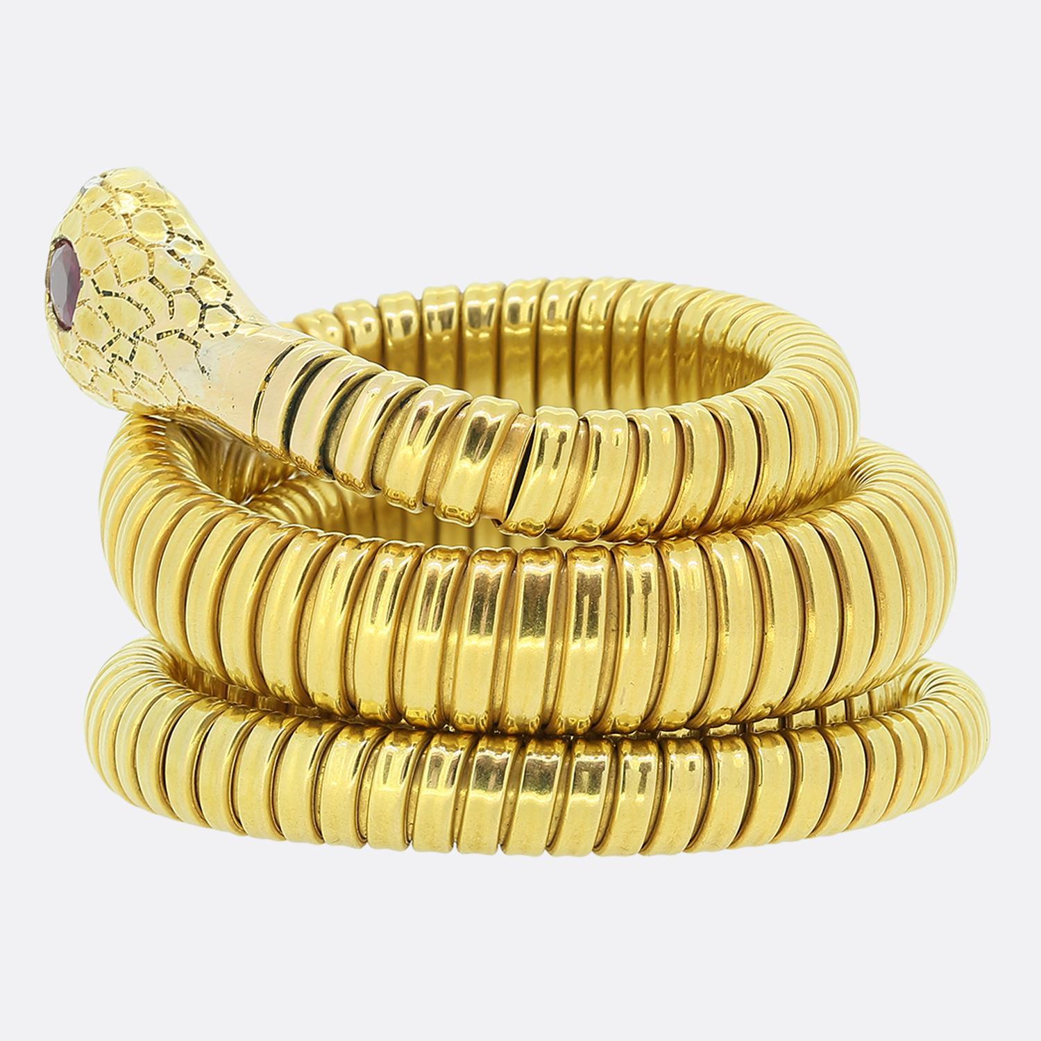 Nous avons ici un remarquable bracelet en serpent enroulé. Cette pièce ancienne a été fabriquée en or jaune 18 carats et témoigne d'une attention exceptionnelle aux détails. Plus particulièrement, la finition en couches de la peau du corps,
