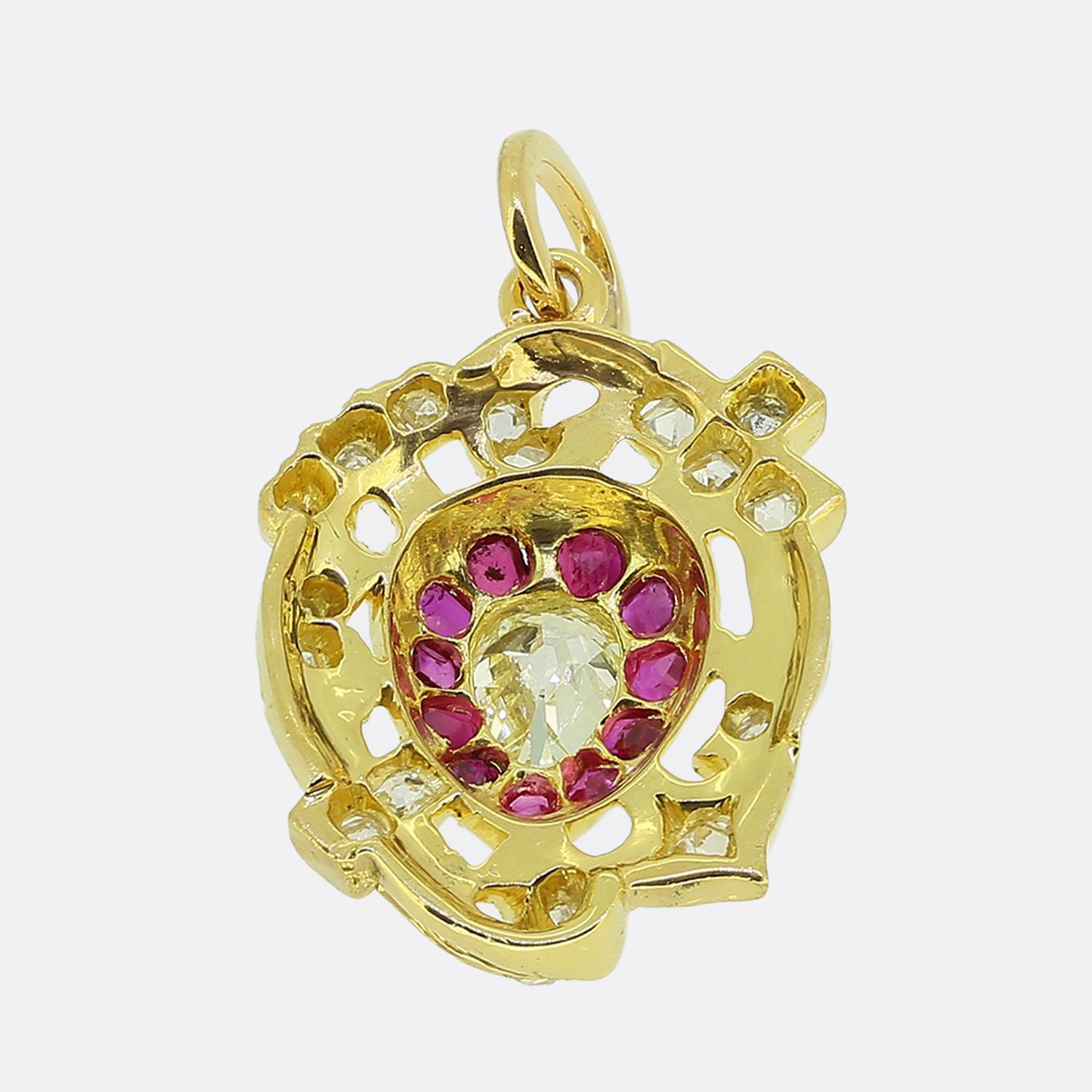 Aquí tenemos un maravilloso colgante de oro de 18 ct que muestra un alto nivel de artesanía victoriana. En su centro, un diamante talla antigua en forma de pera está rodeado de rubíes de un intenso color rojo rosado, creando un llamativo punto
