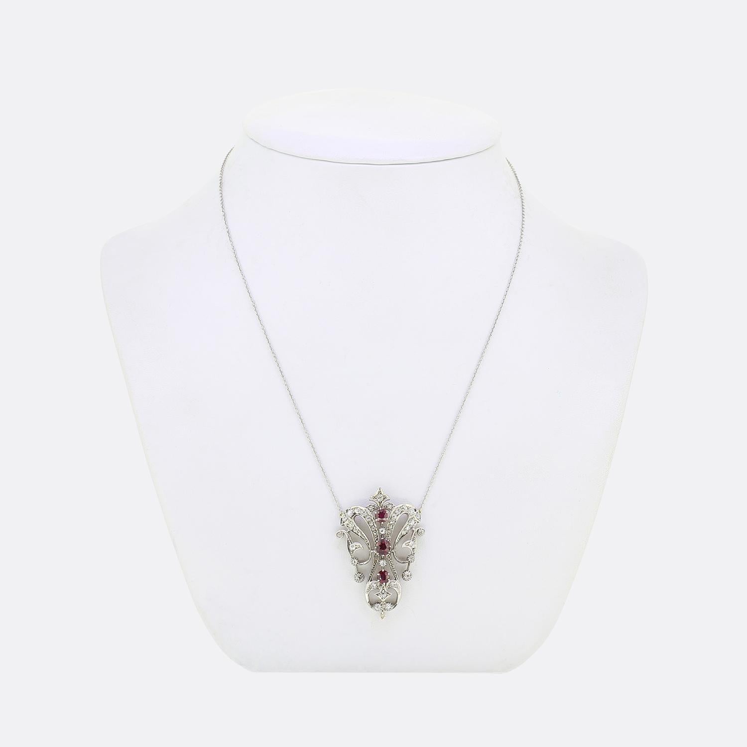This is a wonderful Victorian era ruby and diamond drop necklace. The pendant's open frame consists of three central oval cut rubies which are surrounded by multiple round faceted natural diamonds of differing sizes. The necklace has been crafted in
