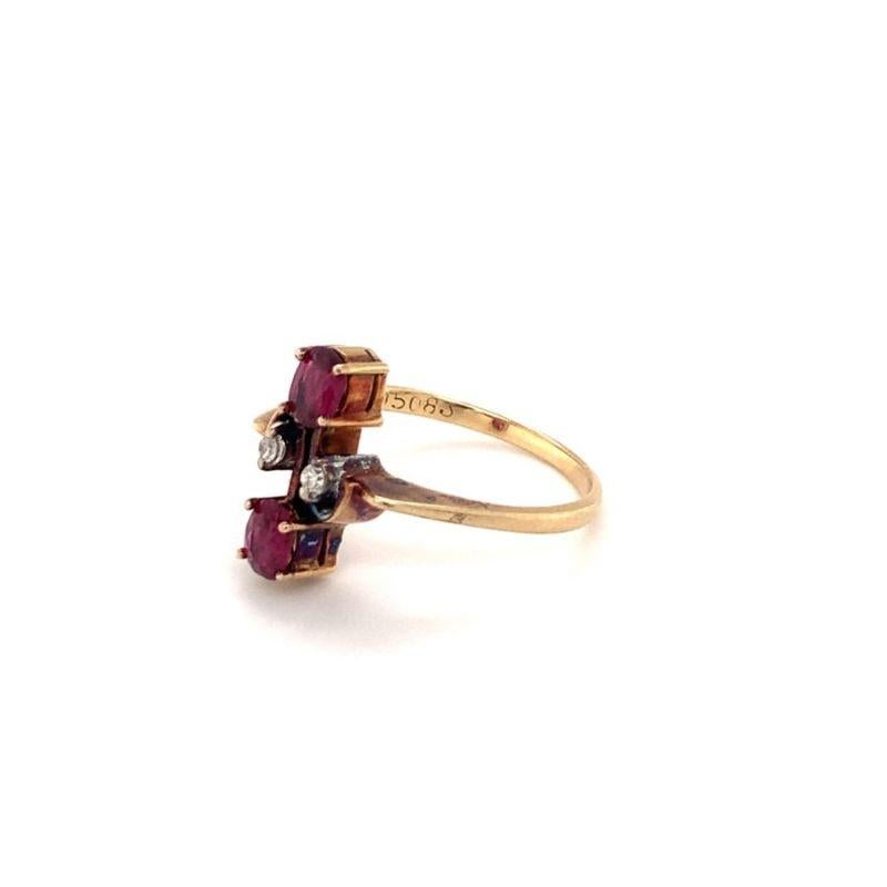 This adorable Victorian-era ring, crafted in 14K yellow gold, showcases two charming oval-shaped rubies totaling 0.70 carats, accented by two delicate single-cut diamonds totaling 0.05 carats. The rich red hue of the rubies pairs beautifully with