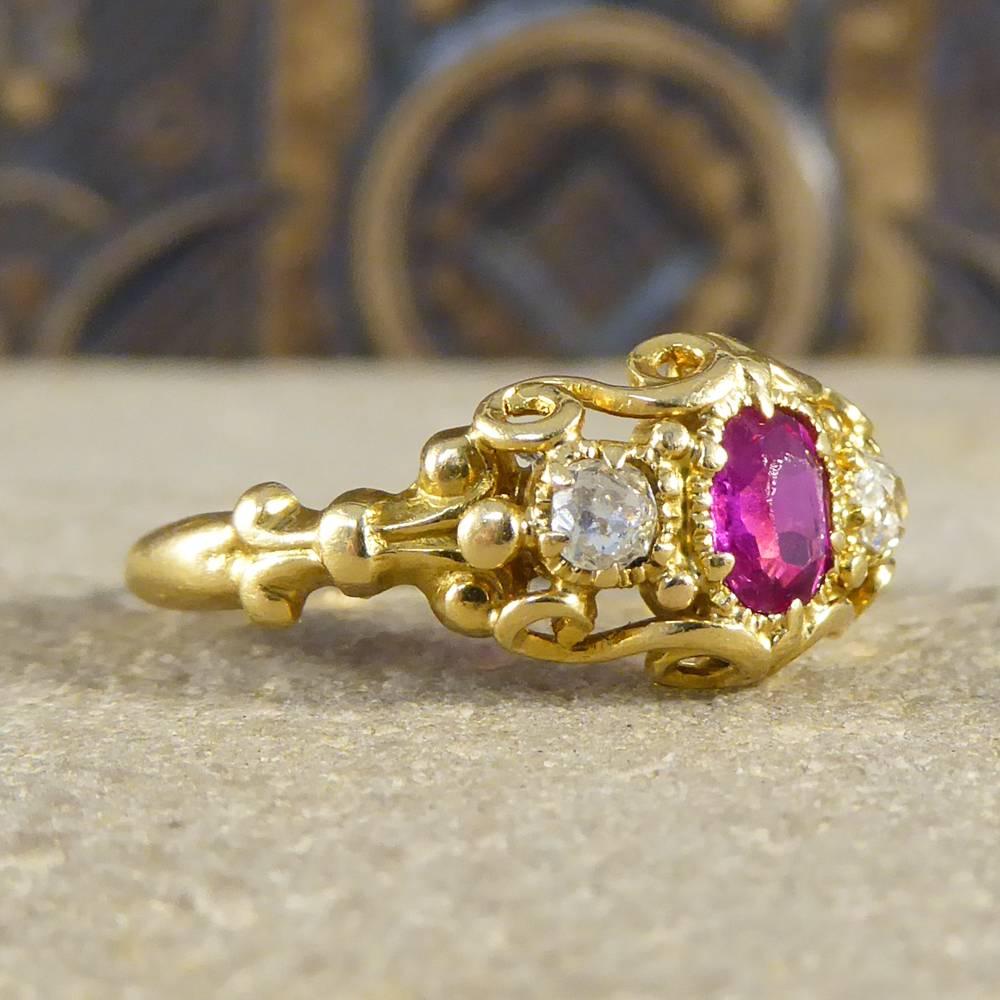 This gorgeous antique ring dates back to the Early Victorian era showing exquisite detail on the head, gallery and shoulders. With one 0.30ct Ruby stone in the centre and two Diamonds to either side, this ring has been crafted in 18ct yellow Gold,