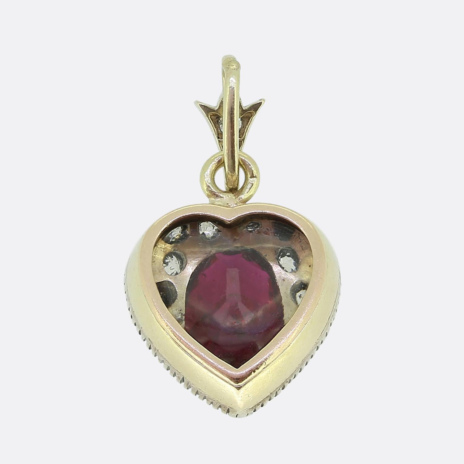 Here we have a Victorian heart-shaped pendant featuring a rich red central ruby which is surrounded by old cut diamonds. The pendant is crafted in 15ct gold with a silver setting for the stones. The glass casing on the reverse side completes the