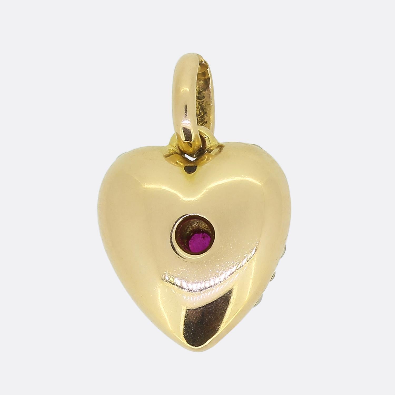 Here we have a charming little pendant dating back to the Victorian period. This antique piece has been crafted from 15ct yellow gold into the shape of a love heart and set with a single round faceted ruby at the centre and surrounding pavé set seed