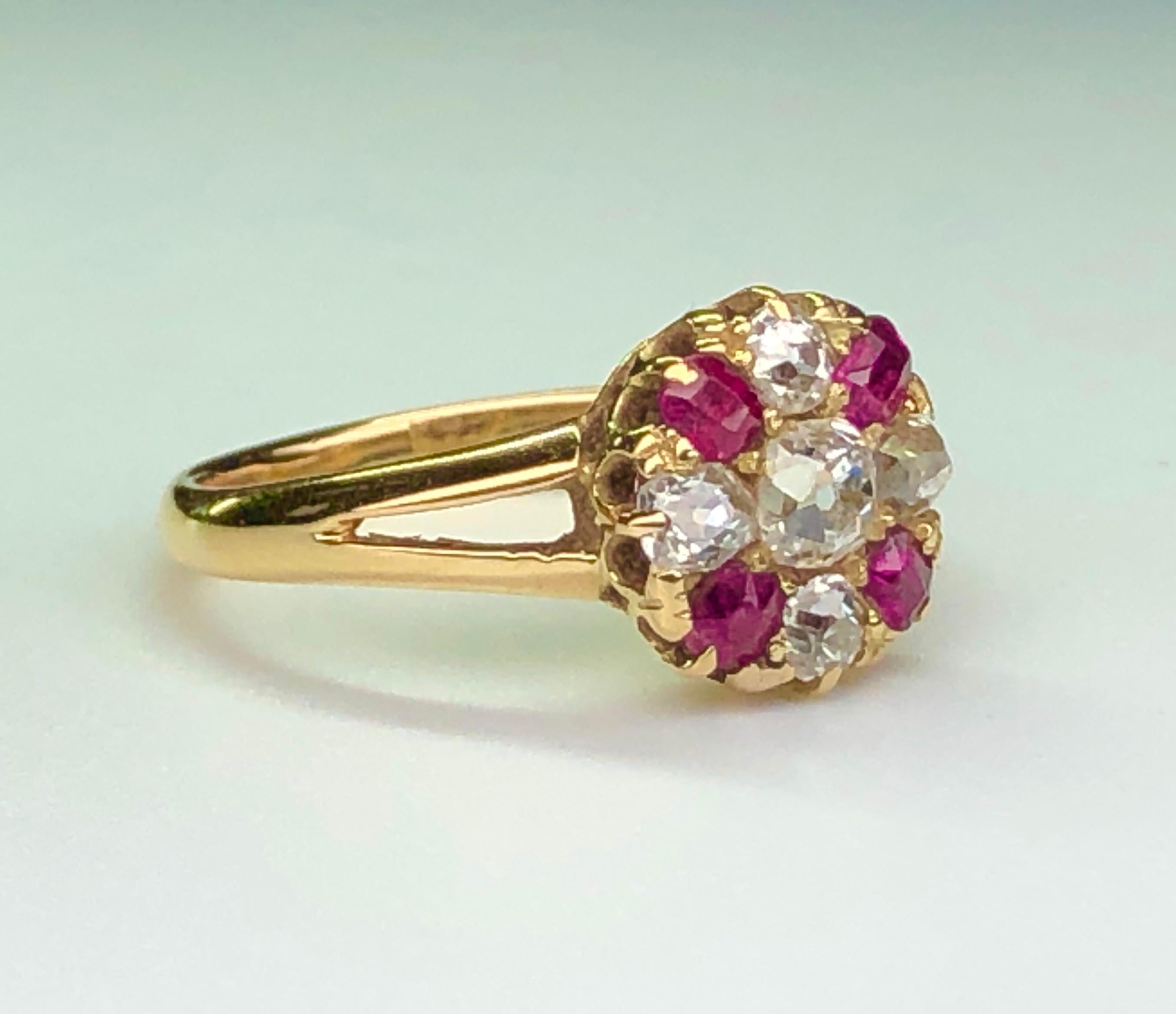 A fine Victorian ring in 18K gold. The central old-cut diamond of approximately 0.2 carats, mounted in claws,  the center stone set well within a border of old cut diamonds and cushion-cut rubies. The ring is in yellow claw settings, to a