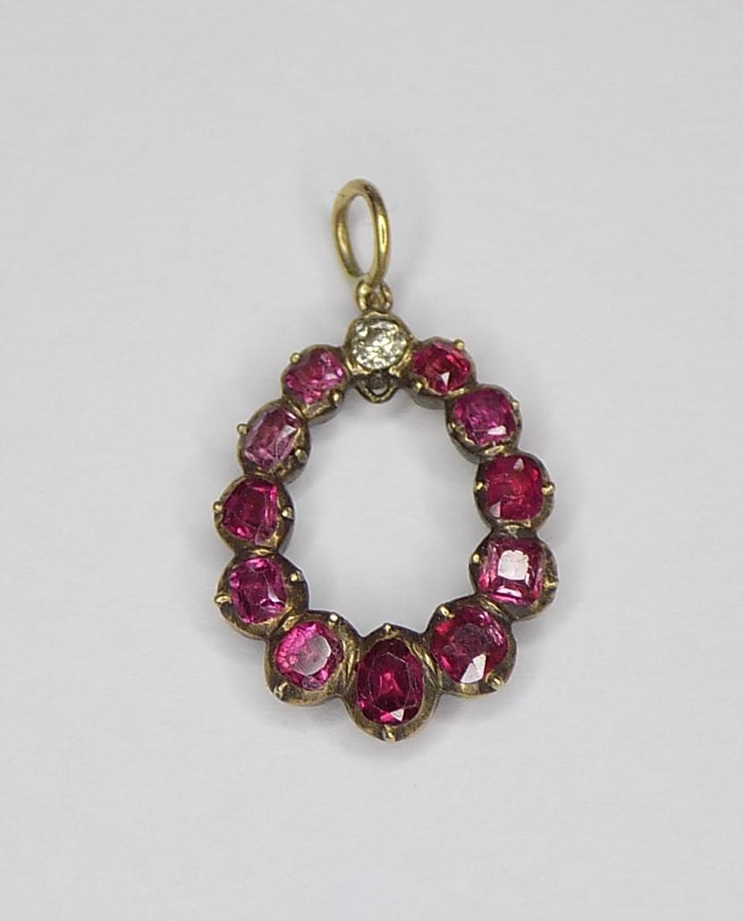 An early Victorian c.1800s Natural Ruby and Diamond pendant. The stones in closed back rose gold setting. English origin.
Drop including jump rings 18mm, Width 13mm.
Rubies from 2 to 3mm.
Weight 1.6gr.
Unmarked.
The pendant in very good condition.