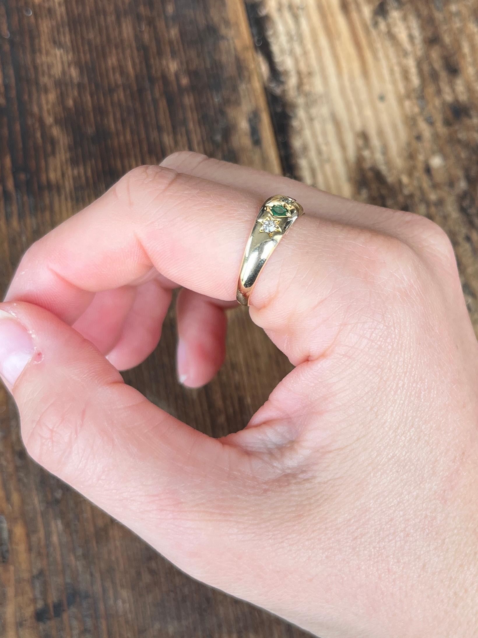 The central diamond in this glossy 18ct gold band measures 7pts and is set in a star setting. The ruby and Emerald that sit either side of this stone measure 10pts and the outer diamonds measure 7pts. Fully hallmarked Birmingham 1898.

Ring Size: O