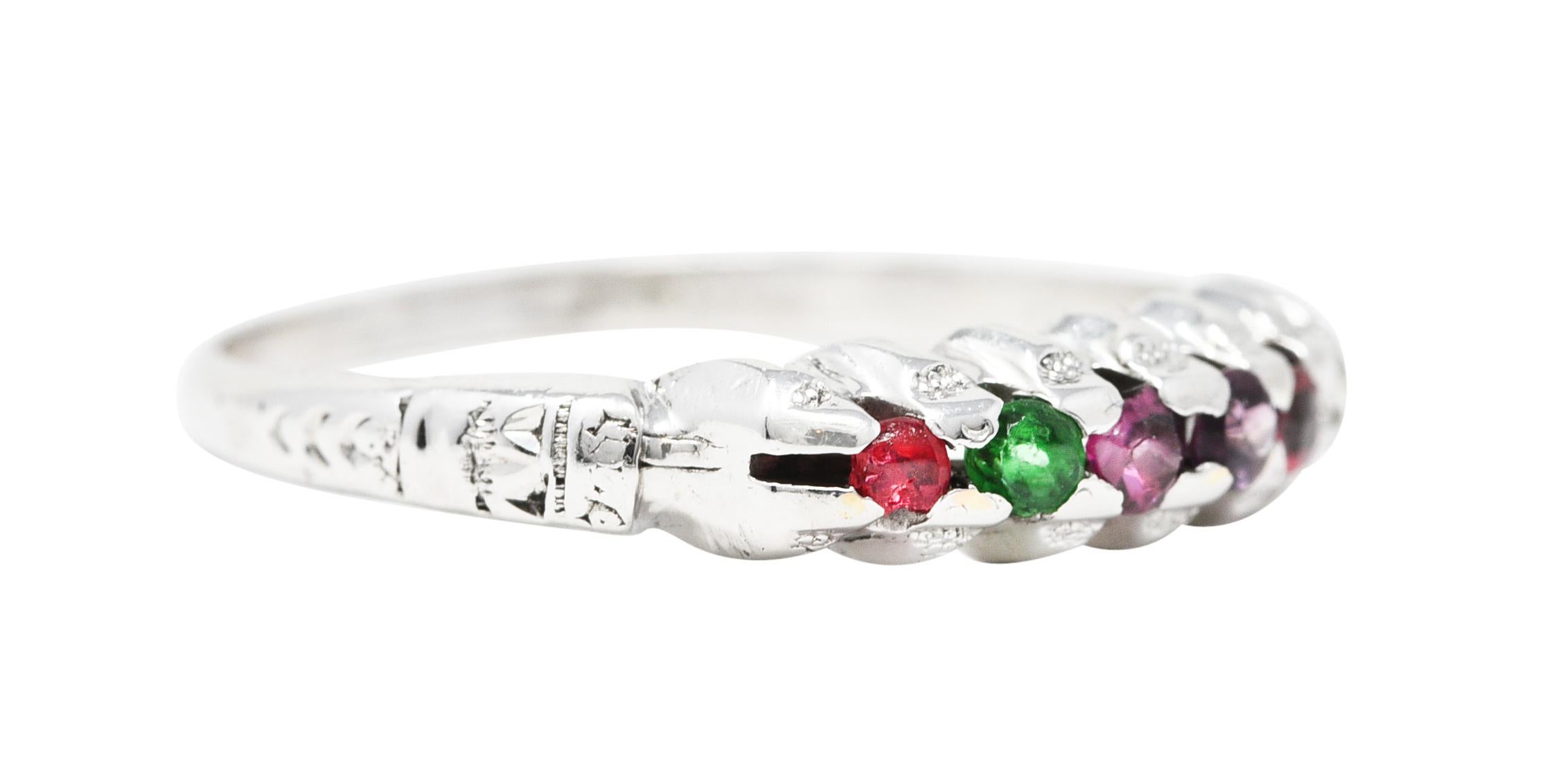 Designed as an acrostic style ring with round cut ruby, emerald, garnet, amethyst ruby, and diamond. Prong set to front - arranged to spell 'Regard', a common motif for period engagement rings. Accented by a grooved profile with engraved floral
