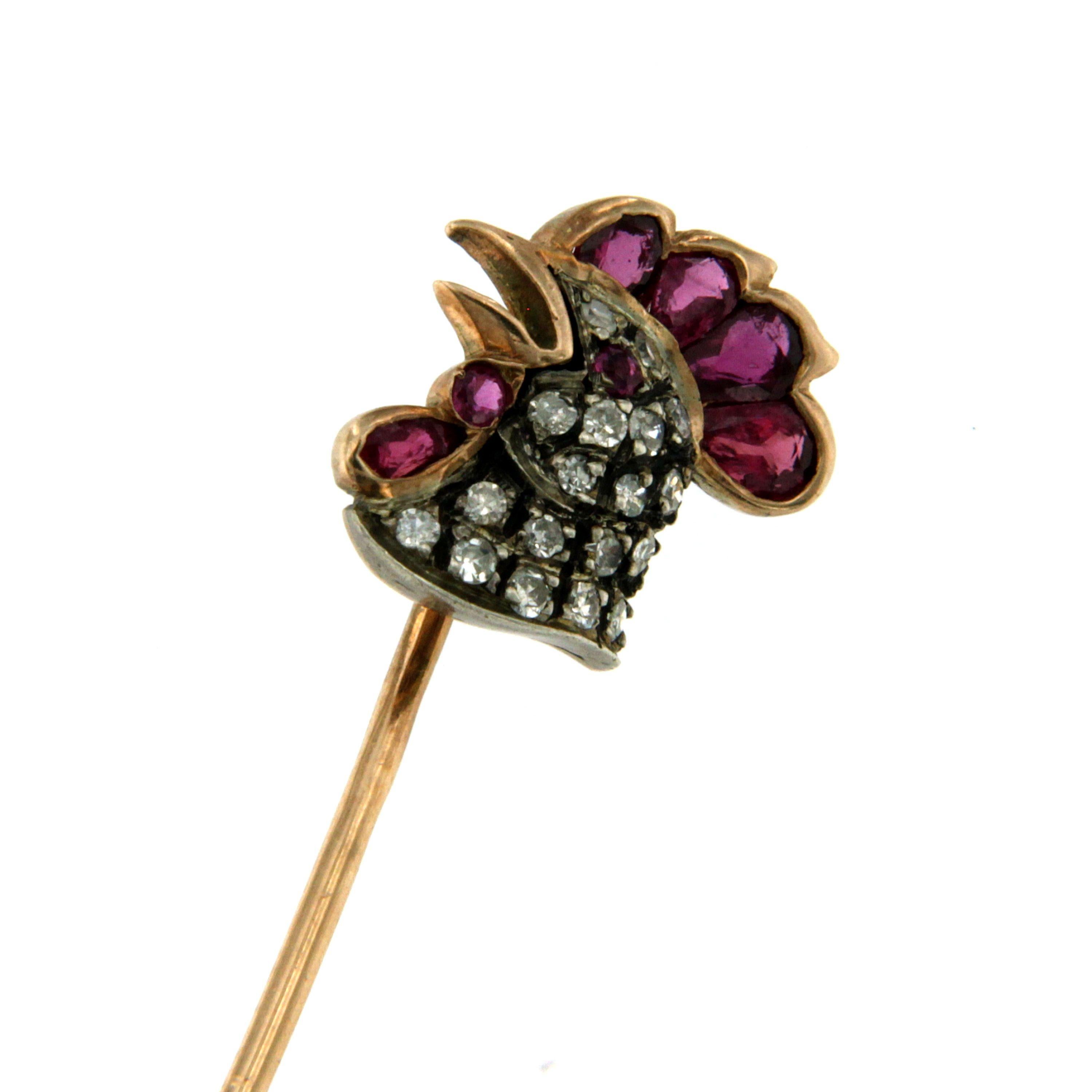 A Victorian 18k Gold Pin decorated with a cock, set with 0.80ct rubies and 0.25 ct Diamonds. Circa 1890

CONDITION: Pre-owned - Excellent 
METAL: 18k Gold
GEM STONE: Ruby 0.80 ct, Diamond 0.25 ct
DESIGN ERA: Victorian
MEASURES: long 2,44 in (6.2