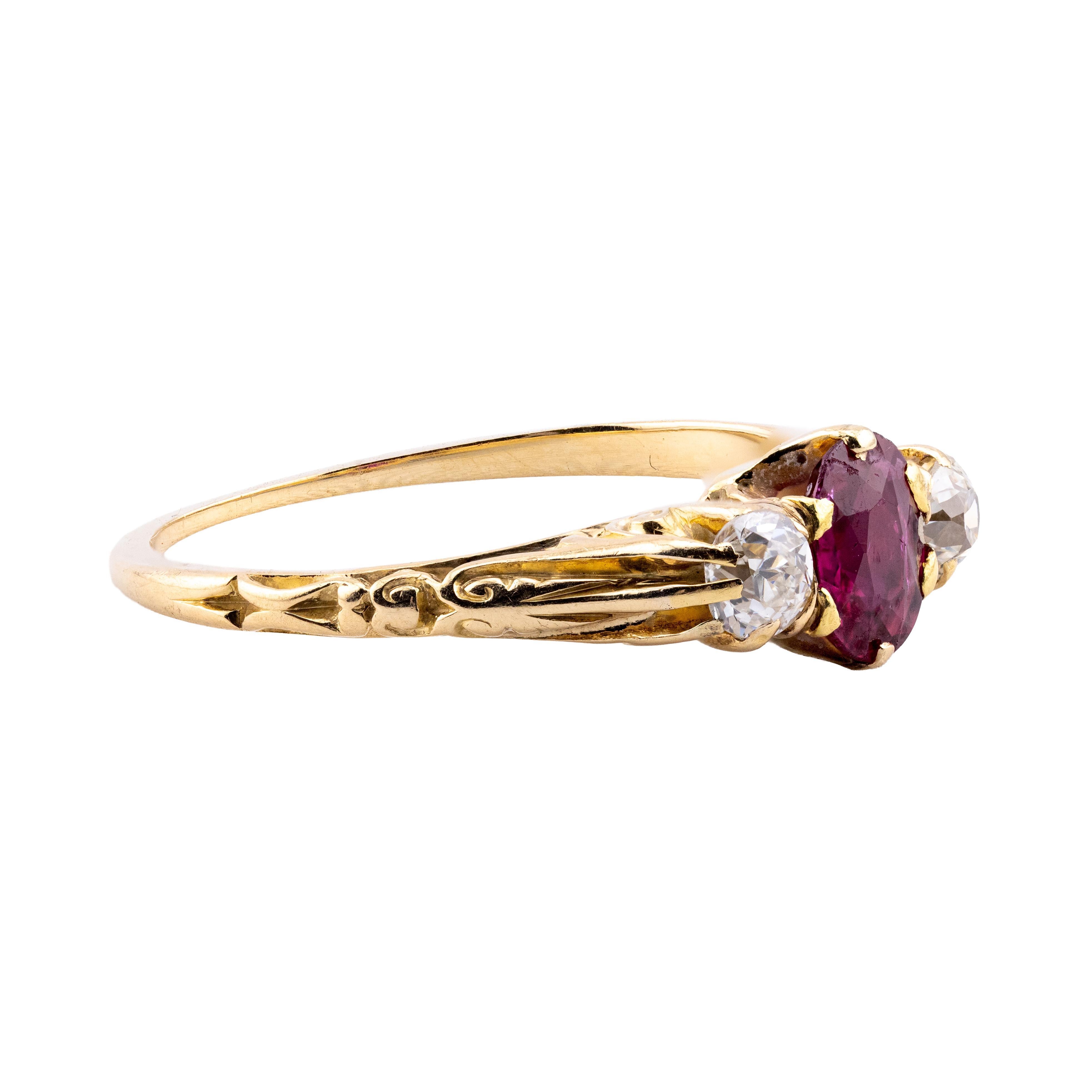 Aston Estate Jewelry Presents:

A captivating three-stone Burma ruby and diamond ring.

Crafted in 18k yellow gold, this piece features an antique cushion-cut Burmese ruby of 0.60 carats as the primary stone, exhibiting a rich vivid red