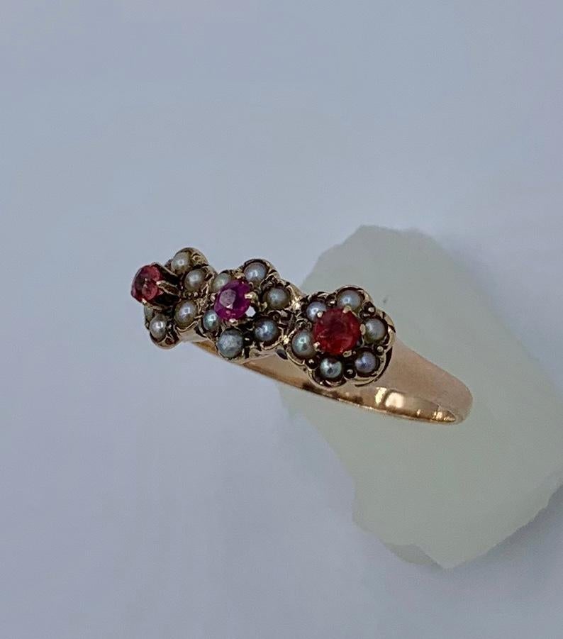 This is a wonderful romantic antique Victorian ring with three lovely flowers with Ruby centers and Pearl petal surrounds.  I love the motif of the three flowers.  The flowers are centered by three gorgeous natural round faceted rubies of a lovely