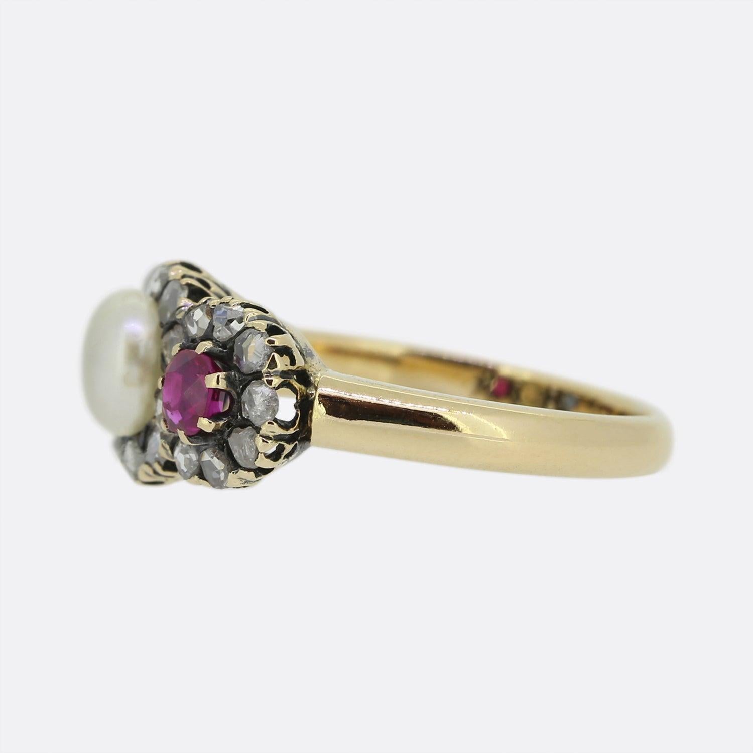 This is a wonderful 18ct yellow gold Victorian triple cluster ring. The centre of the ring is set with a button pearl with a lovely white lustre. On one side there is a ruby and the other a sapphire. Surrounding these three stones there are