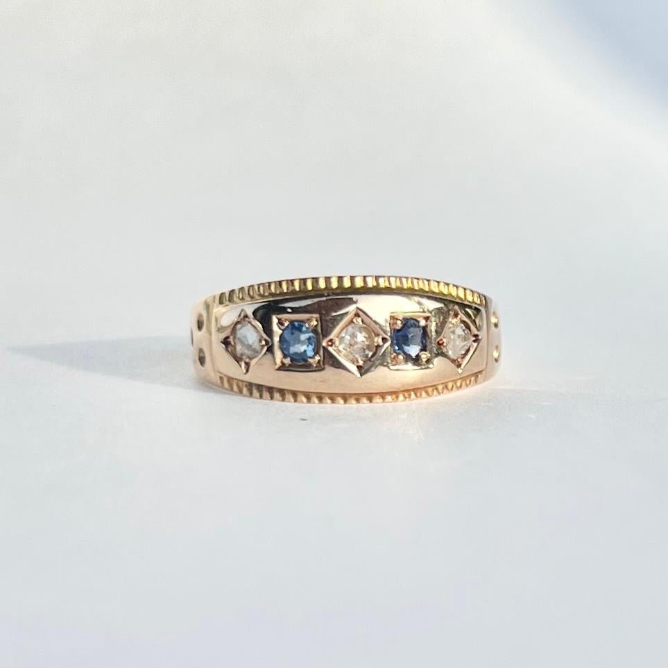 Set within the gold there are two blue and gorgeous sapphires totalling approx 14pts and set within square settings. Sat between the sapphires are three old mine cut diamonds. These total approx 21pts. The ring is modelled in 15ct gold. Fully