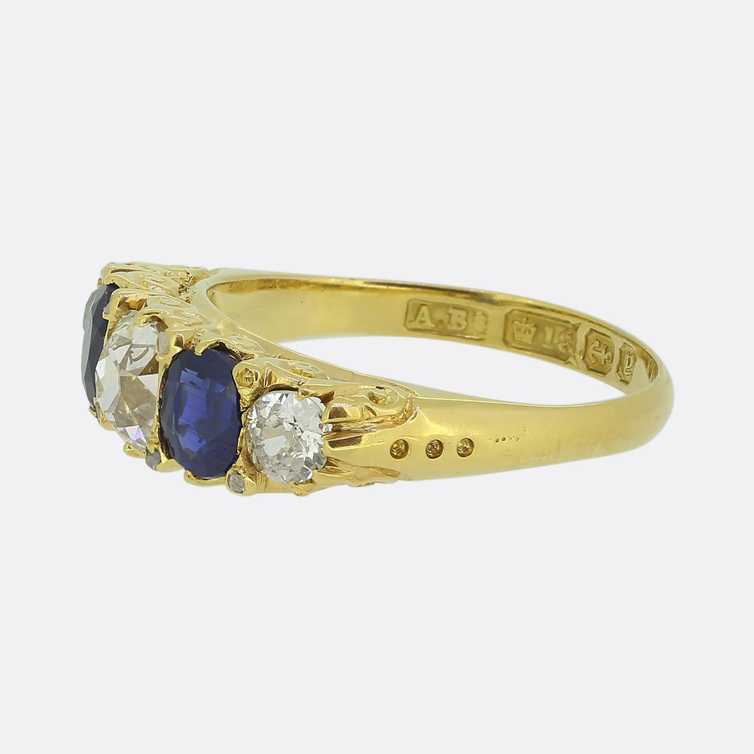 Here we have a classically styled five-stone ring taken from the Victorian era. This antique piece has been crafted from a rich 18ct yellow gold and showcases a single old cushion cut diamond at the centre of the face. This proud principal stone is
