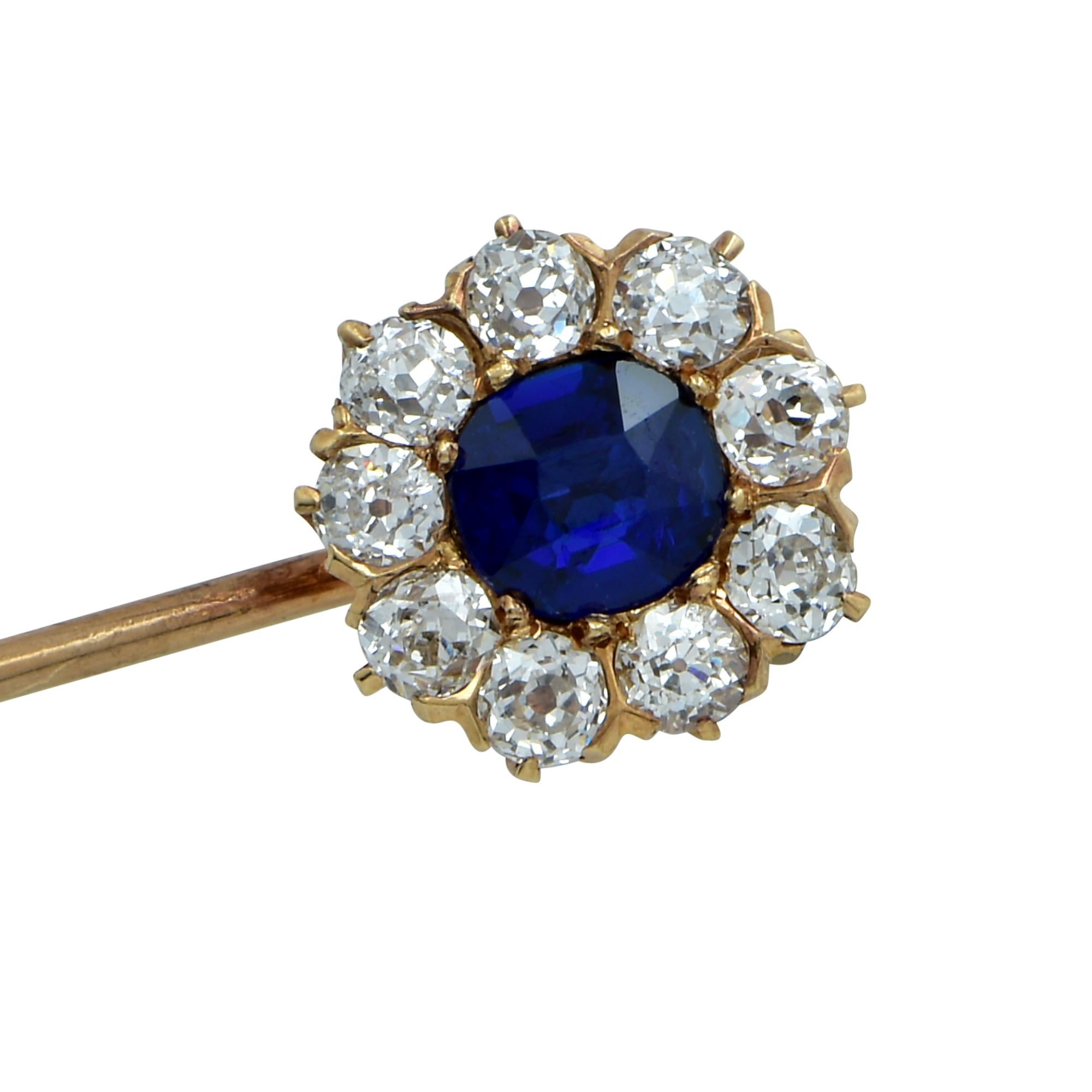 Gorgeous Victorian brooch pin crafted in 18K yellow gold, showcasing a stunning AGL Certified non-heated blue Cushion Cut Sapphire originating in Cambodia, surrounded by nine Old European Cut diamonds weighing .80 carats total, G color, VS clarity.