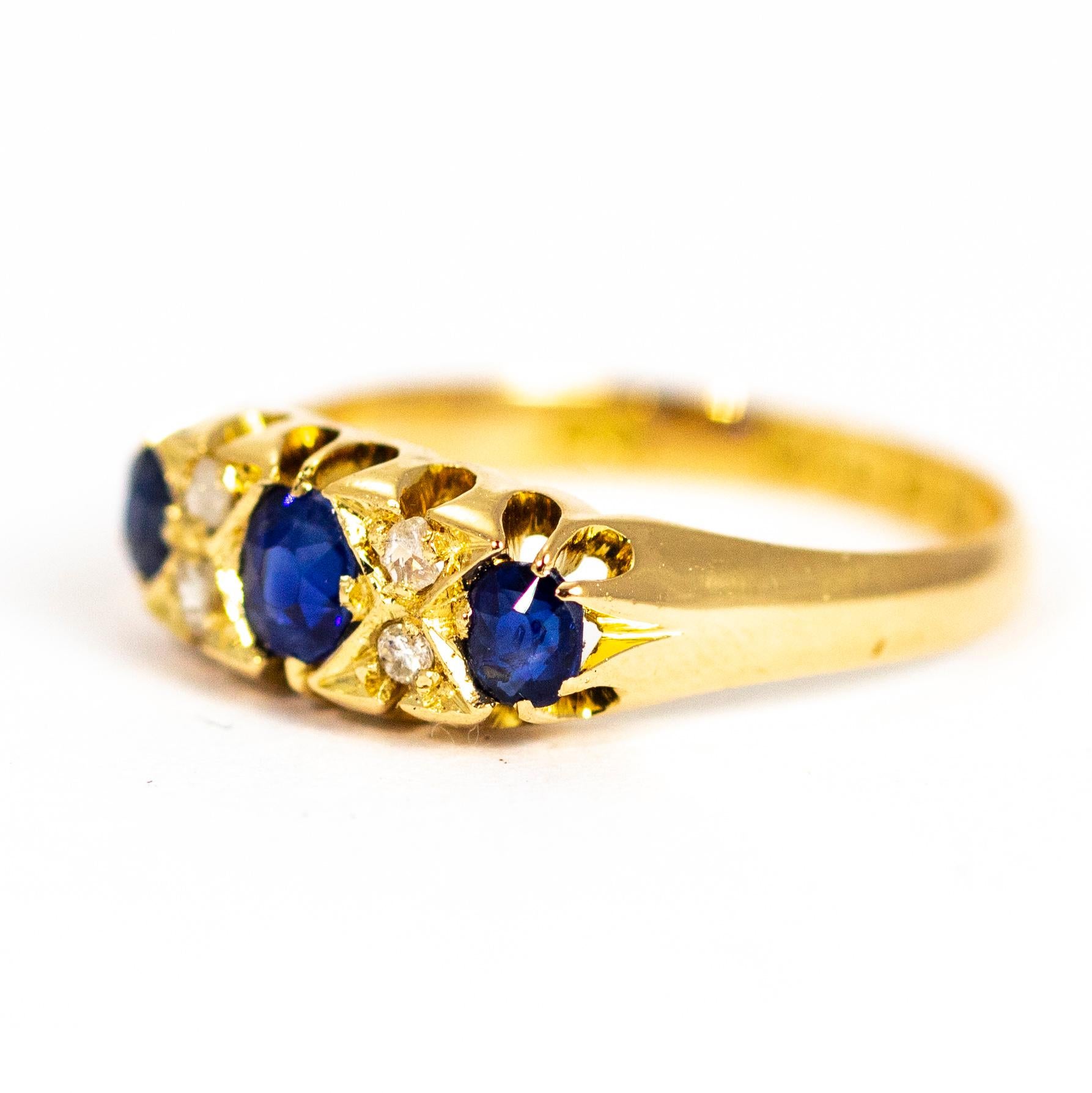 Three beautiful deep blue sapphires measuring a total of approximately 40pts sit perfectly on top of this 18ct gold band. In between the sapphires there are two pairs of diamonds which are set in 'X' settings, they almost look like kisses! Made in