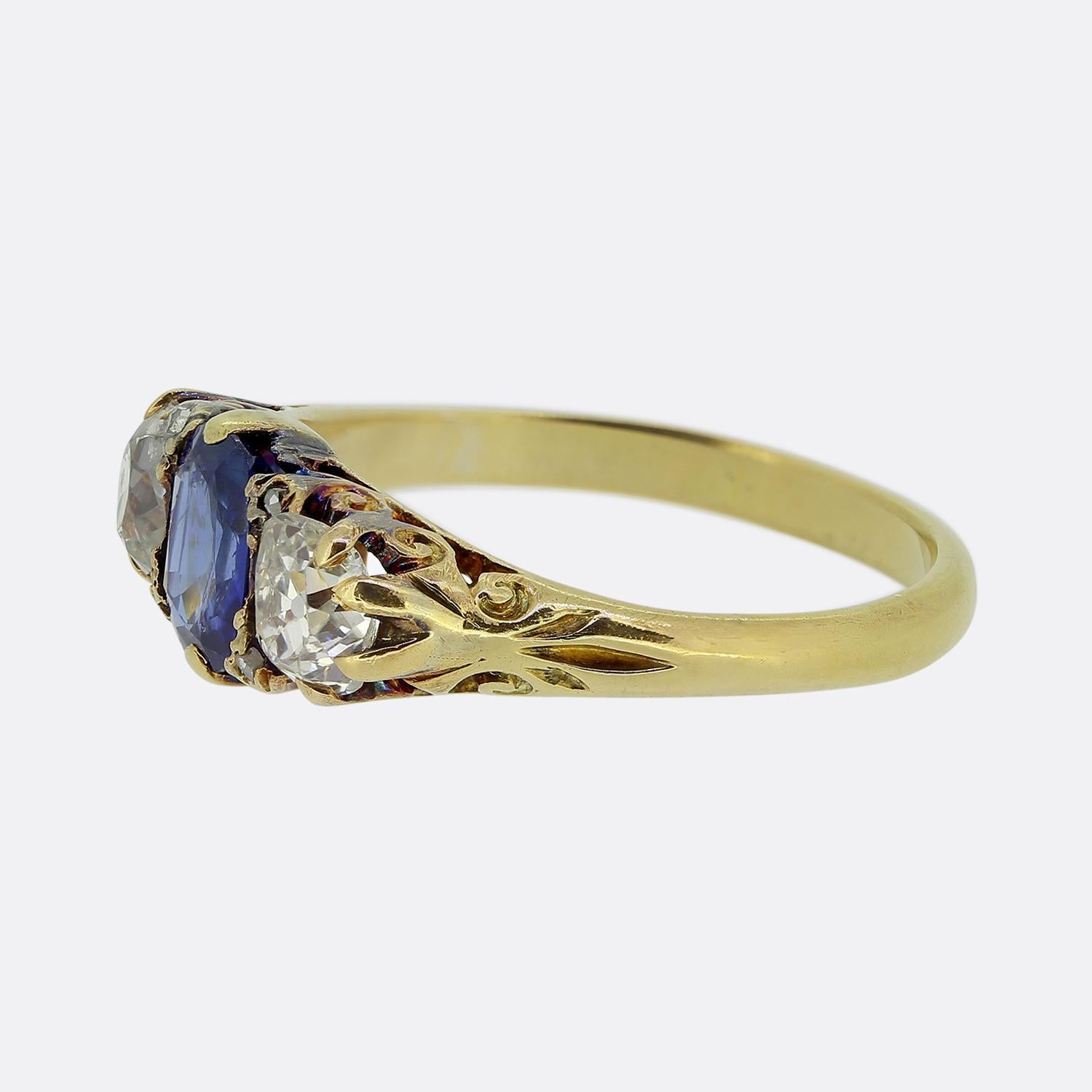 Qui abbiamo un anello a tre pietre in stile classico, risalente all'epoca vittoriana. Questo pezzo d'antiquariato è stato realizzato in ricco oro giallo 18 carati e presenta al centro un sorprendente zaffiro blu. Accanto a questa pietra principale