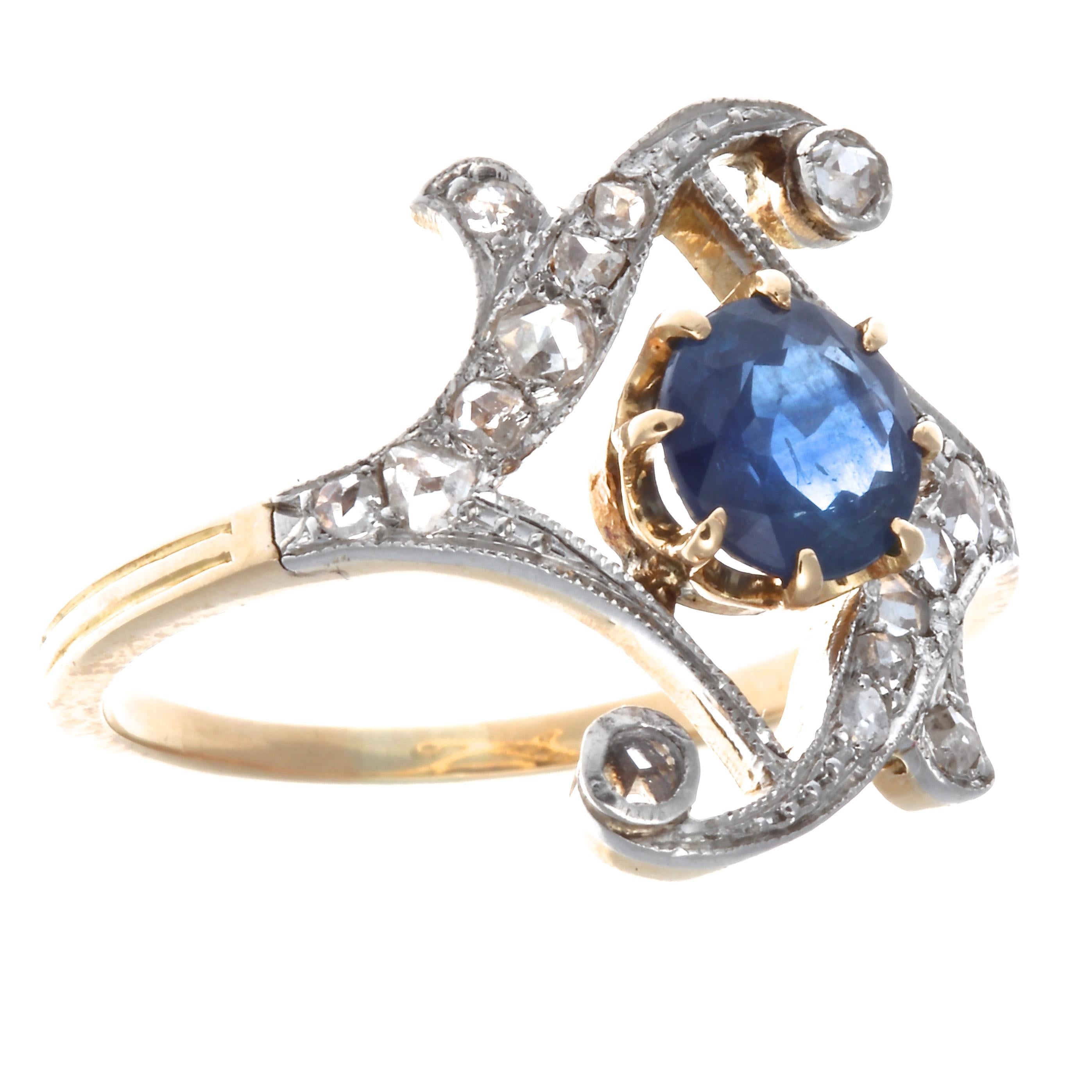 As graceful as a dancer in flight. The lustrous round cut translucent blue sapphire weighs 0.90 carats. Accented by 16 diamonds weighing approximately 0.50 carats, I,J color SI clarity.  This Victorian ring is in 18K gold, size 7 3/4 and may easily