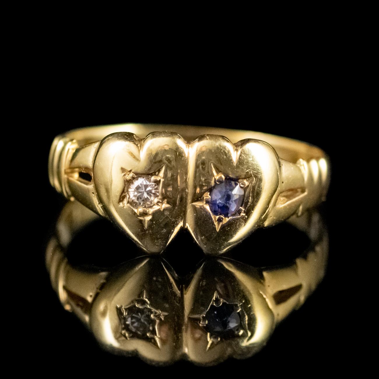 This lovely Antique Victorian ring has been commissioned in 18ct Yellow Gold. It features the shape of two hearts, one set with a sparkling old cut Diamond weighing 0.08ct and the other set with a beautiful old cut deep blue Sapphire also weighing