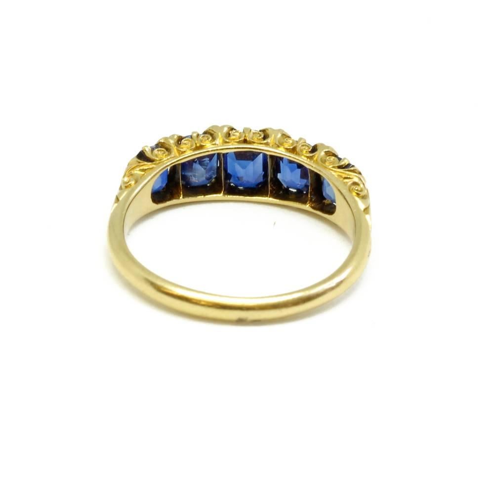 A Victorian five stone sapphire half hoop ring mounted in 18ct yellow gold, having pairs of tiny rose cut diamond accents between each sapphire. English, circa 1880.
