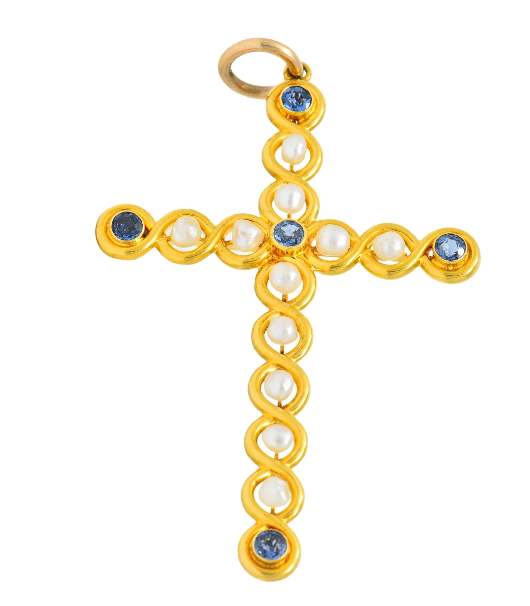 Pendant is designed as a cross with brightly polished gold that wraps around gemstones set throughout

With eleven very well-matched natural pearls, white in body color with very good to excellent luster

Accented by five round cut sapphire weighing