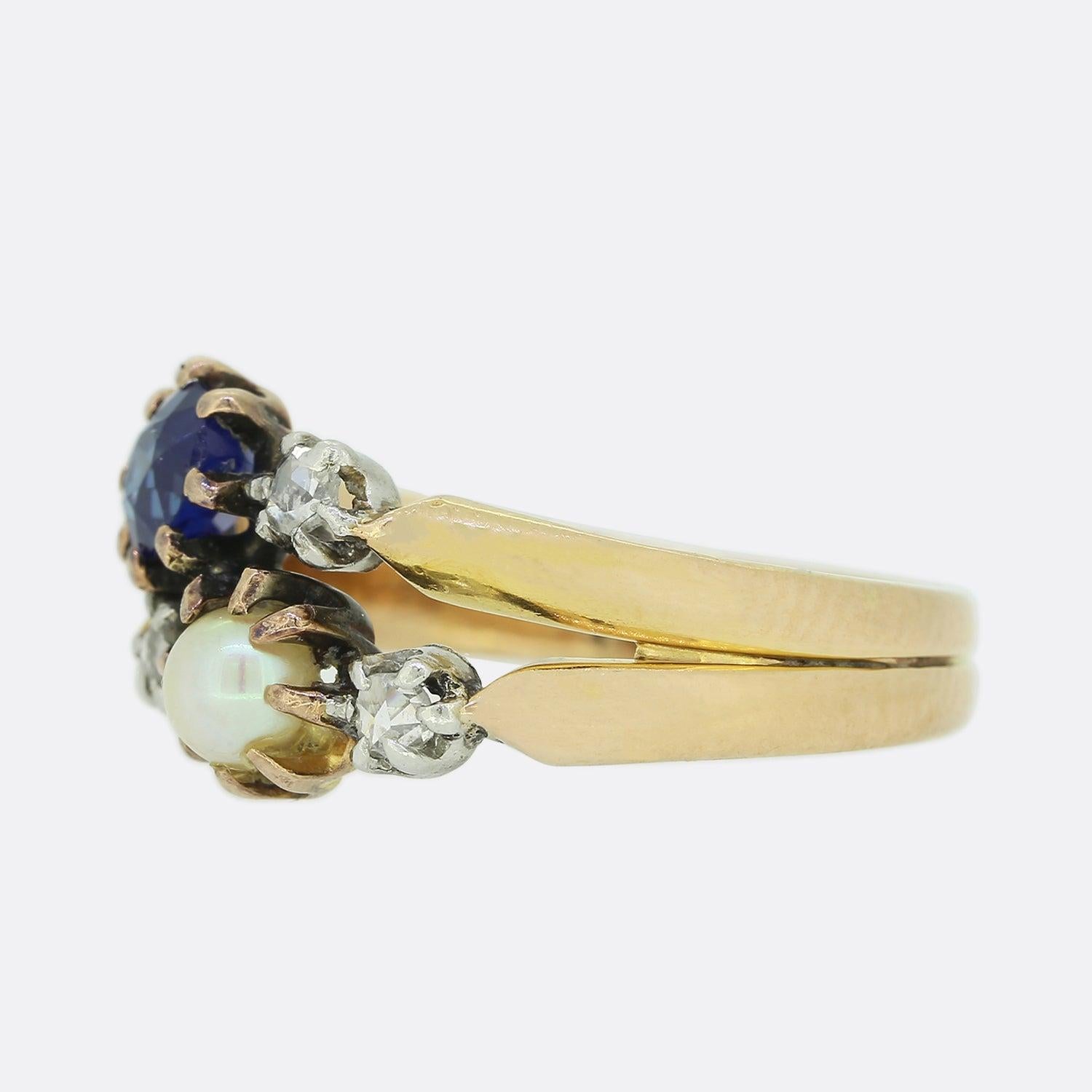 This is a Victorian 15ct yellow gold sapphire, pearl and diamond ring. The ring is crafted in a double banded fashion which graduates inwardly towards the face where we find a single round sapphire and natural pearl; both of which are individually