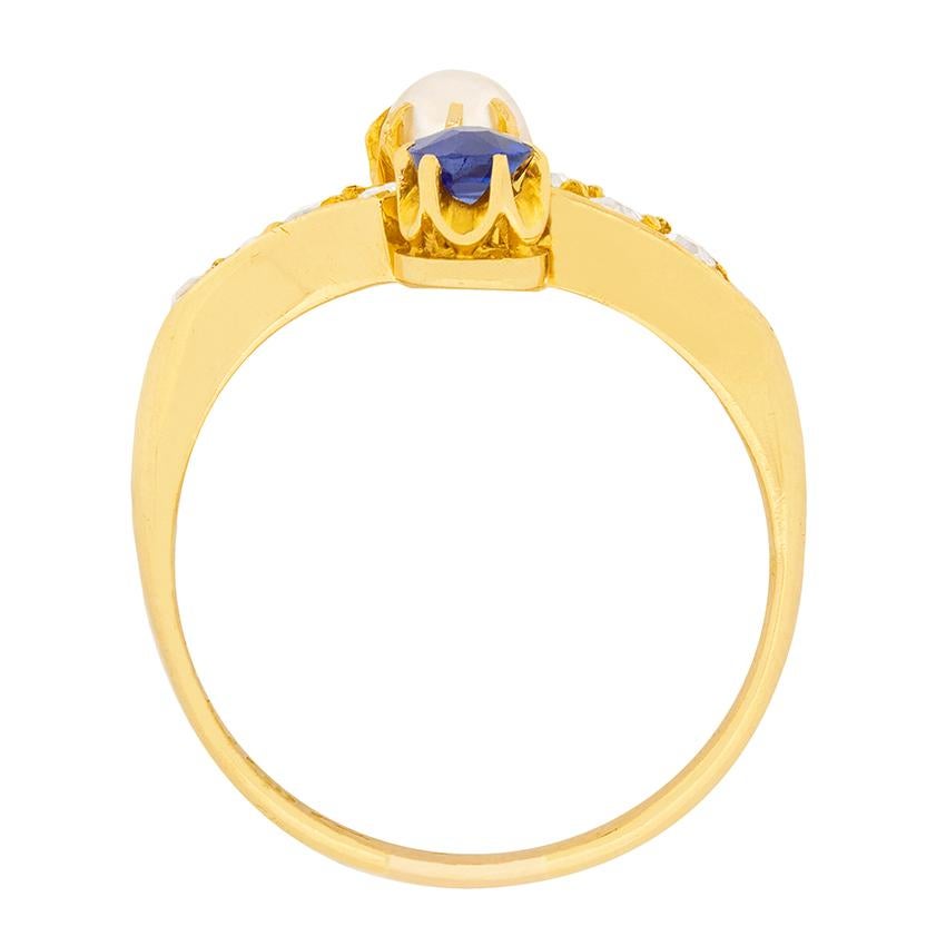 This beautiful and unique ring features a 0.20 carat blue sapphire set opposite a natural pearl. The pearl measures approximately 4mm and both the pearl and sapphire, have been claw set using 18 carat yellow gold. On both the twisting shoulders are