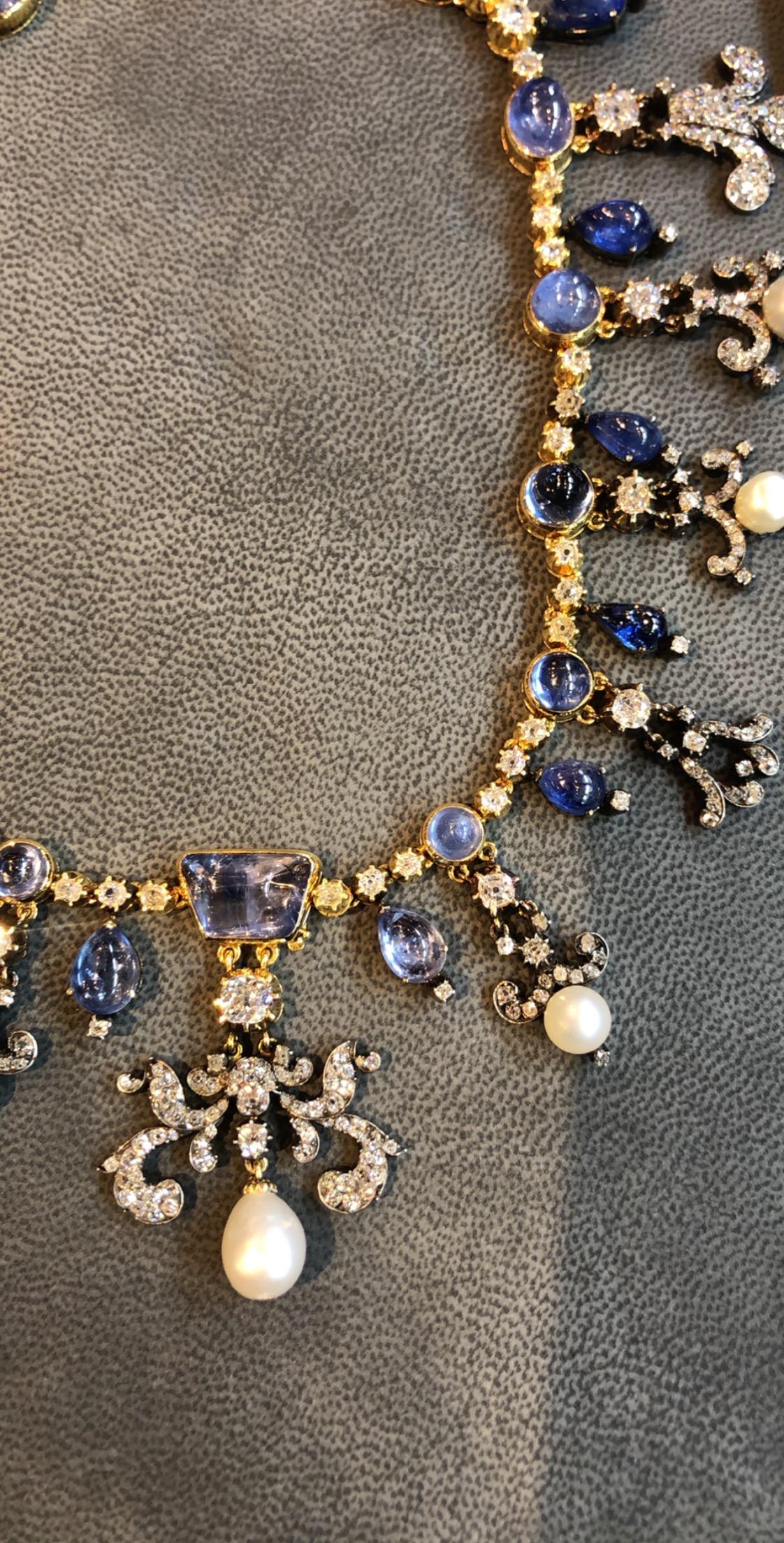Victorian Sapphire Natural Pearl & Diamond fleur de lys Necklace 
set with cabochon  & pear shape sapphires, including cushion & round cut diamonds and natural pearls.
Approx Natural Pearl Weight:  34.48 Cts
Approx Sapphire Weight: 75.00-85.00