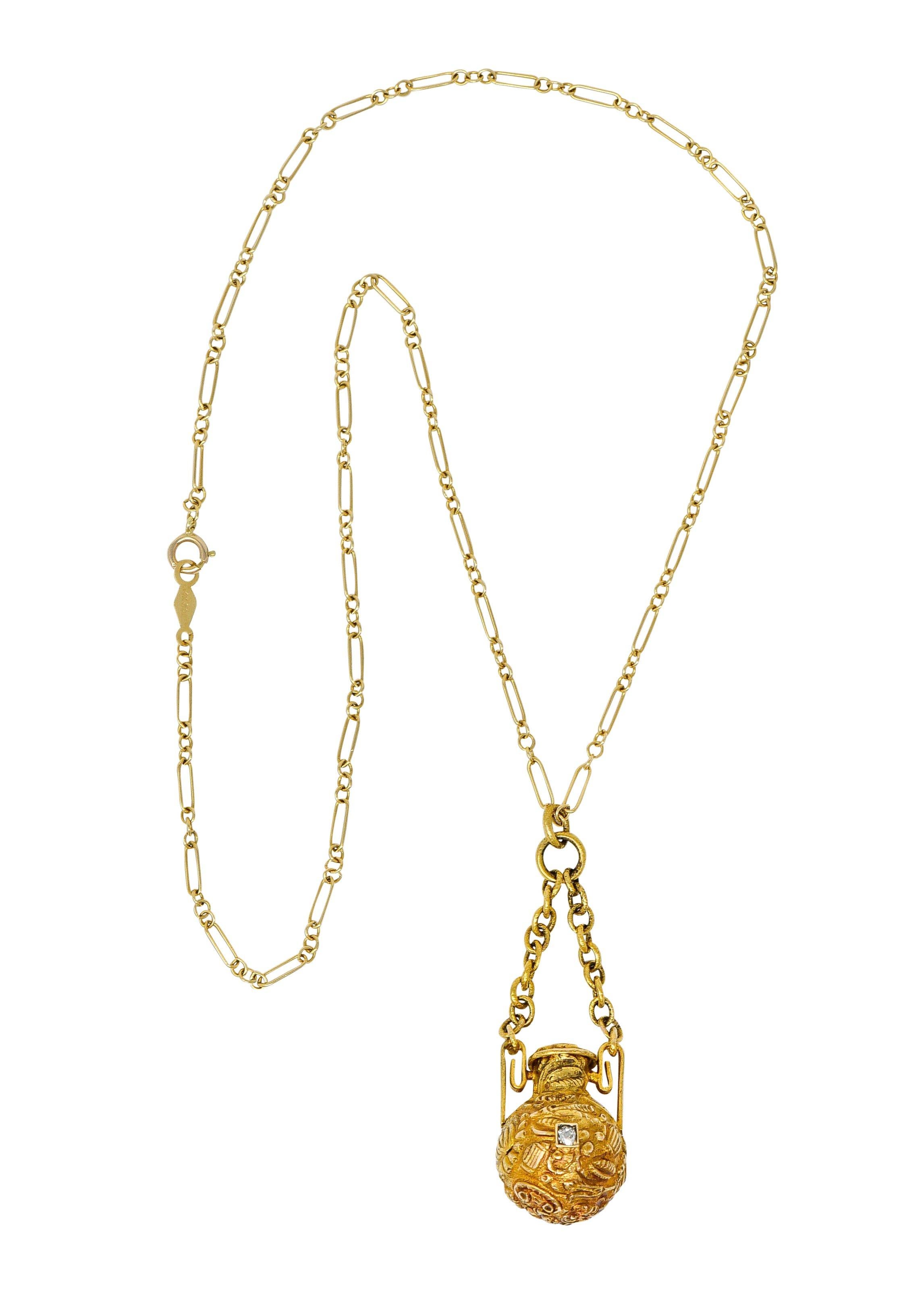 Paperclip style chain suspends a swagged amphora style container

Featuring floral and foliate repousse and a lid that opens on a hinge

Accented by a bead set ruby, sapphire, and diamond weighing in total approximately 0.47 carat

Completed by a