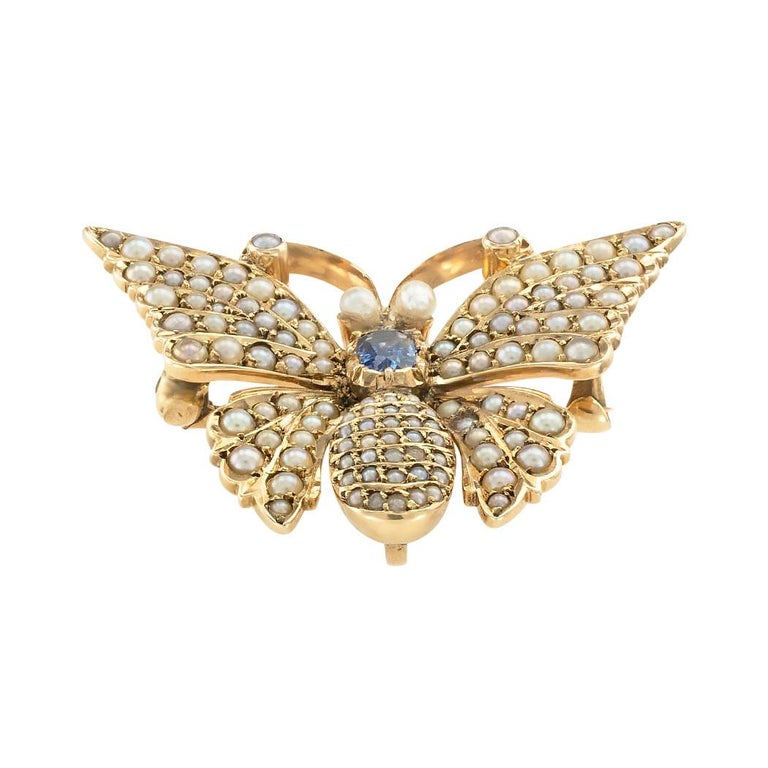 Victorian blue sapphire seed pearl and yellow gold butterfly brooch pendant with watch hook circa 1890. 

SPECIFICATIONS:

GEMSTONES:  one oblong cushion-shaped faceted blue sapphire.

OTHER GEMSTONES:  seed pearls of various sizes pavé-set over