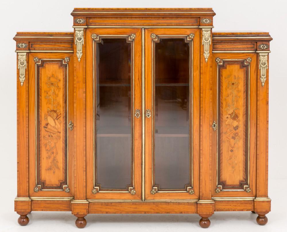 Superb Quality Victorian Satinwood Side Cabinet standing on Bun feet.
circa 1860
This piece has 2 x Central Bevelled Glazed doors flanked by doors with wonderful Marquetry inlays depicting musical instruments.
The whole cabinet being crossbanded