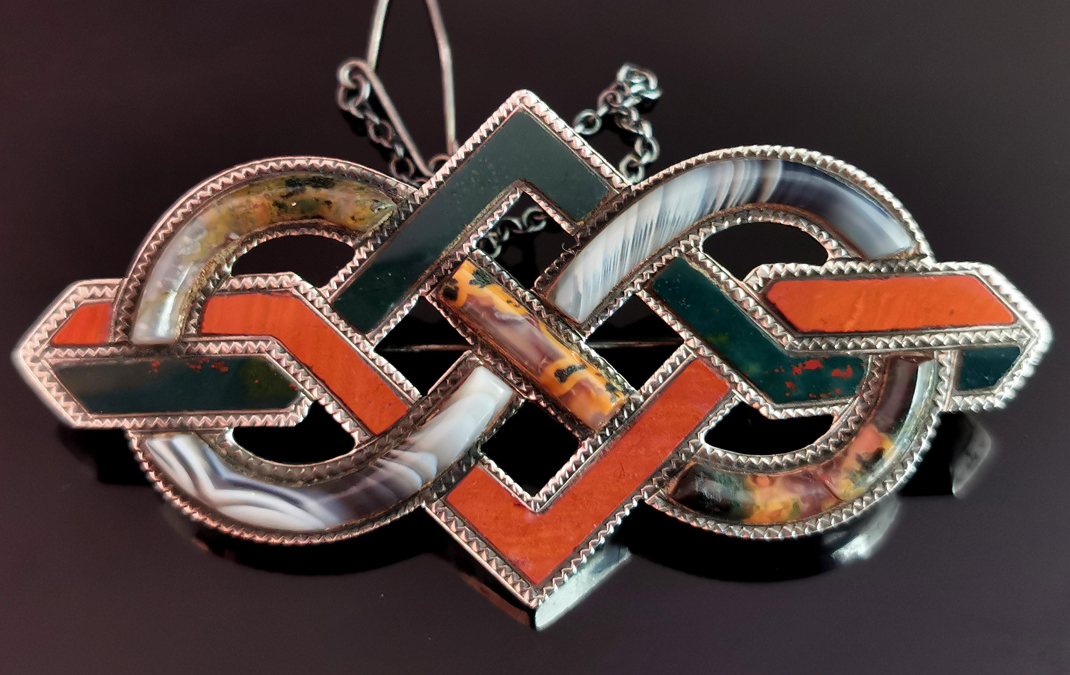 A beautiful and grand antique, Scottish agate and Silver knot brooch.

It has an infinity loop design, interwoven with a geometric pattern to form a knot shape.

The brooch is set with high polished agate including Red Jasper, Bloodstone, Montrose