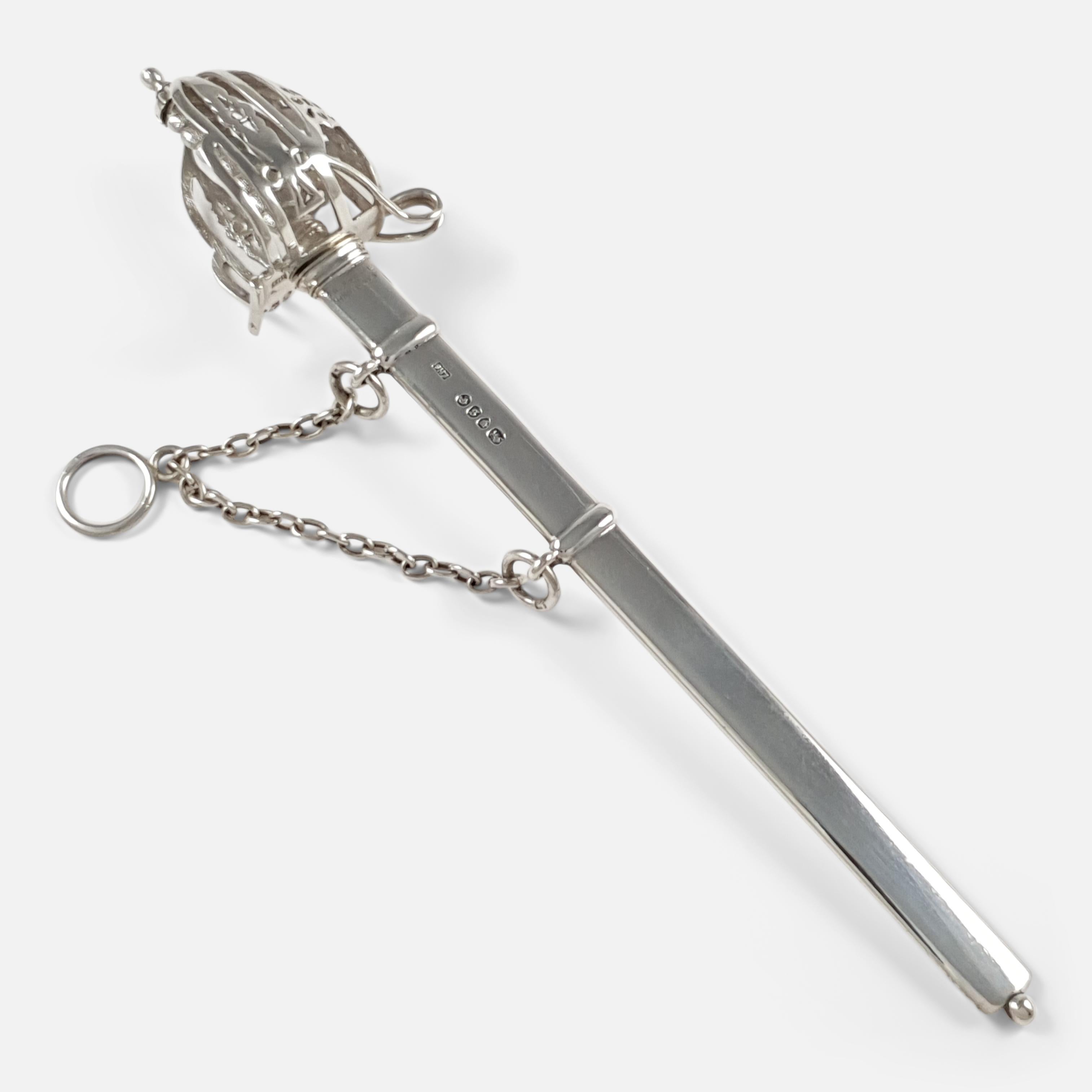 A Victorian Sterling Silver replica Scottish Basket-hilted broad sword letter opener with scabbard and short chain. The basket hilted handle is beautifully crafted with a pierced decoration, leading to a double edged blade, held within a scabbard on